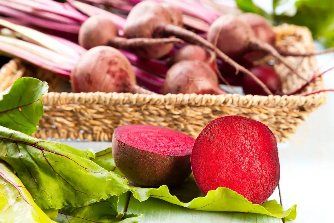 Buraki, źr&oacute;dło betainy w kosmetykach, w koszyku i na zielonych liściach.