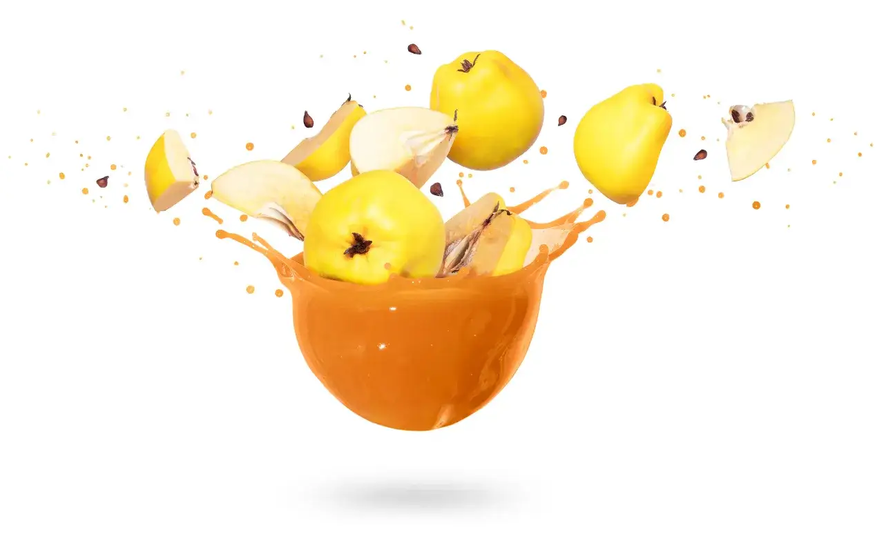 Rozbryzgujący się sok z pigwy w misce, z owocami i pestkami w powietrzu. Warto znać sok z pigwy przeciwwskazania.