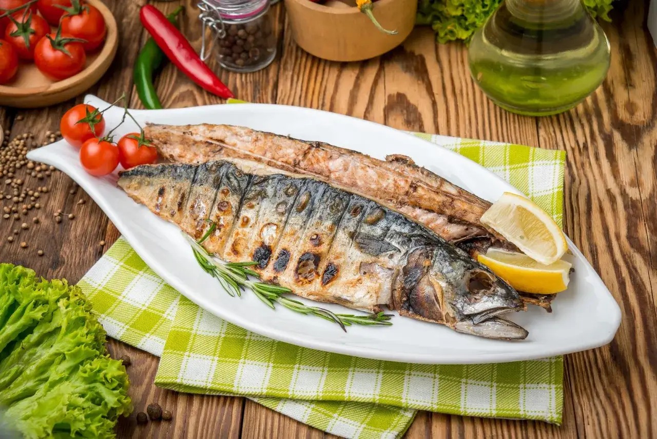Idealne co na grilla: soczysty, grillowany makrela z cytryną i rozmarynem, podany z pomidorkami i sałatą.
