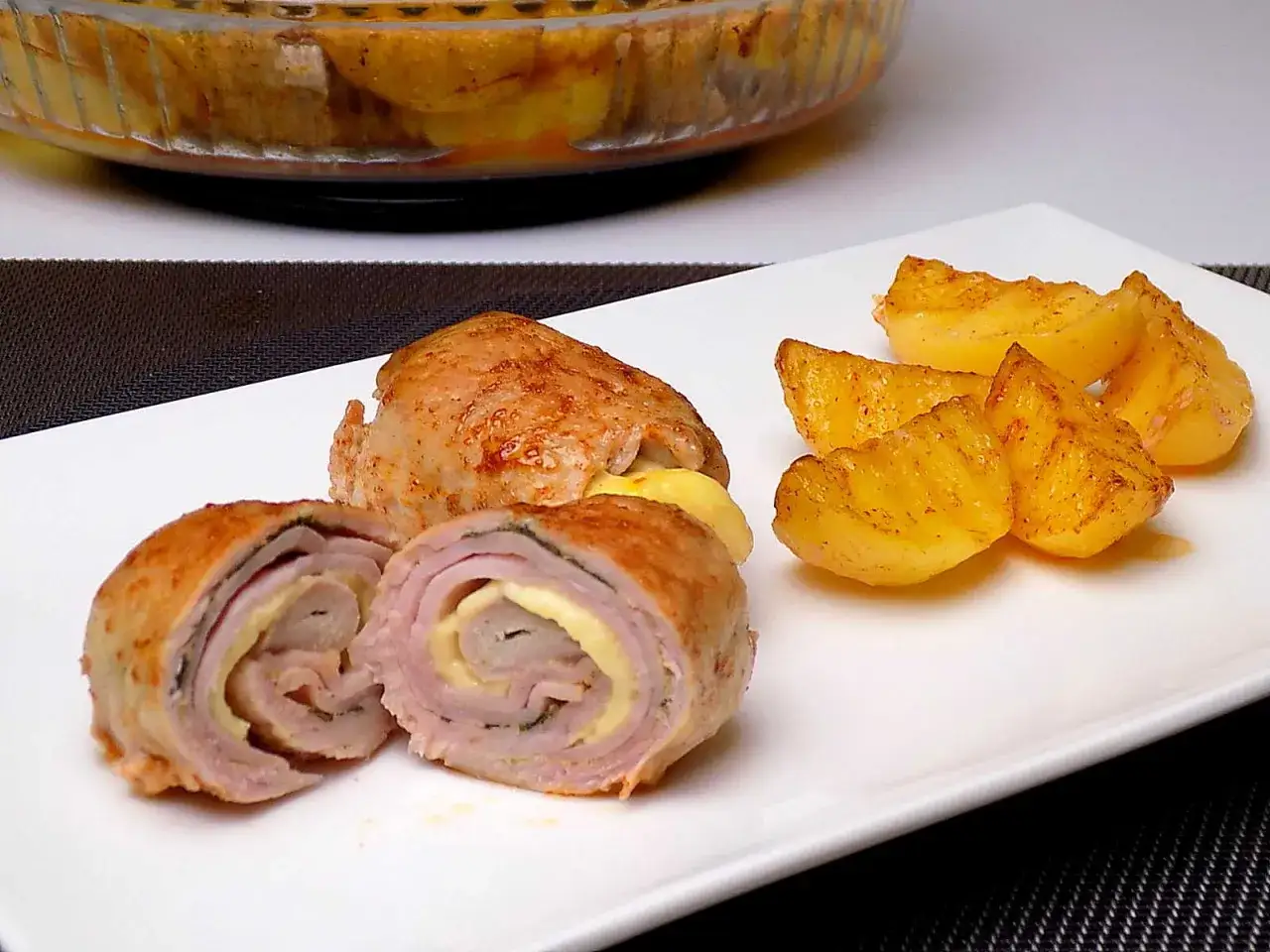 Roladki ze schabu z serem i szynką, podane z pieczonymi ziemniakami. Idealne pytanie: co ze schabu na obiad?