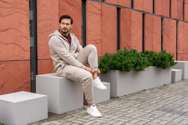 Mężczyzna w streetwearowej stylizacji z bluzą przewieszoną przez ramię