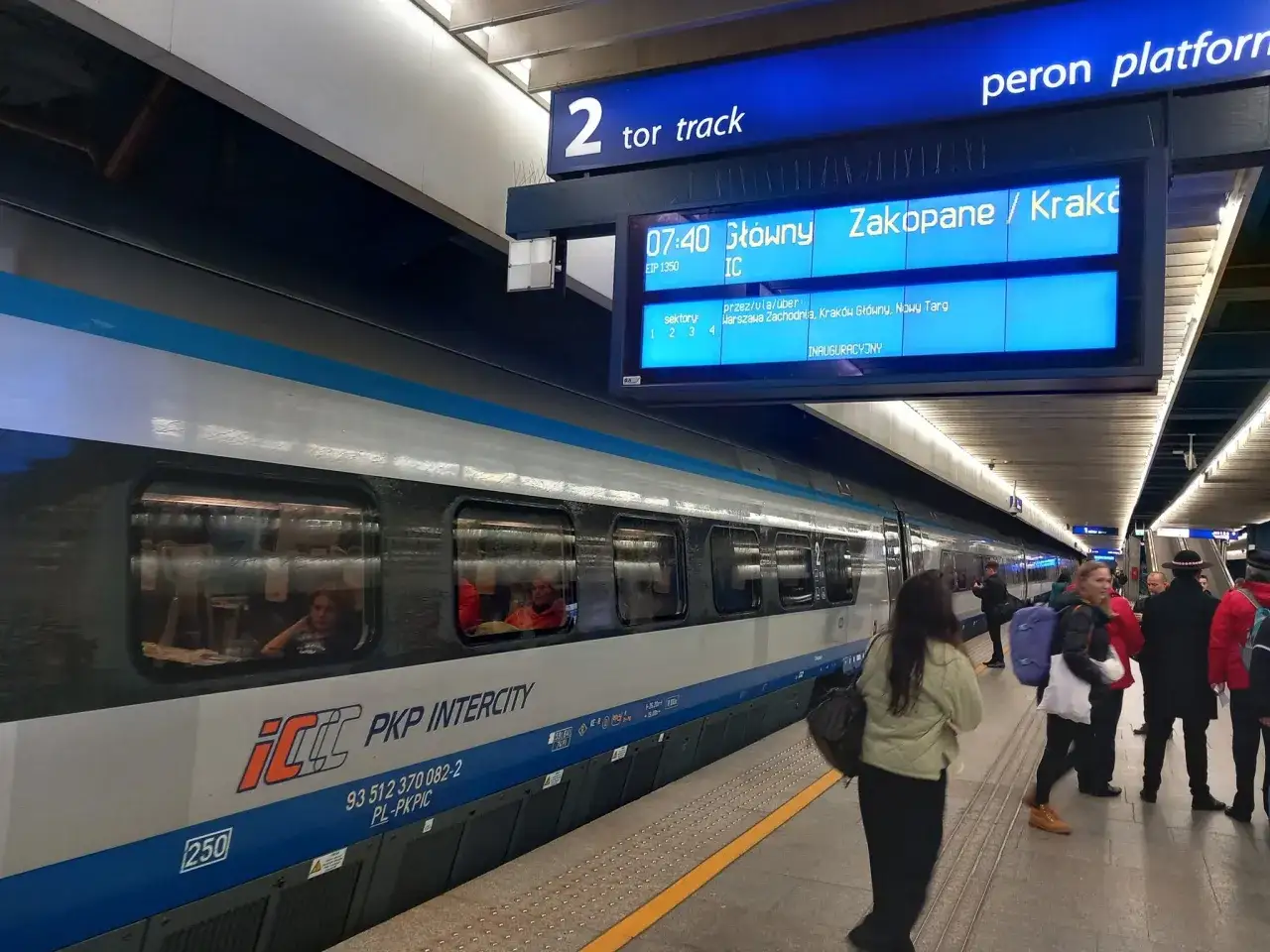 Pociąg PKP Intercity na torze 2, gotowy do odjazdu do Zakopanego. Ludzie czekają na peronie.