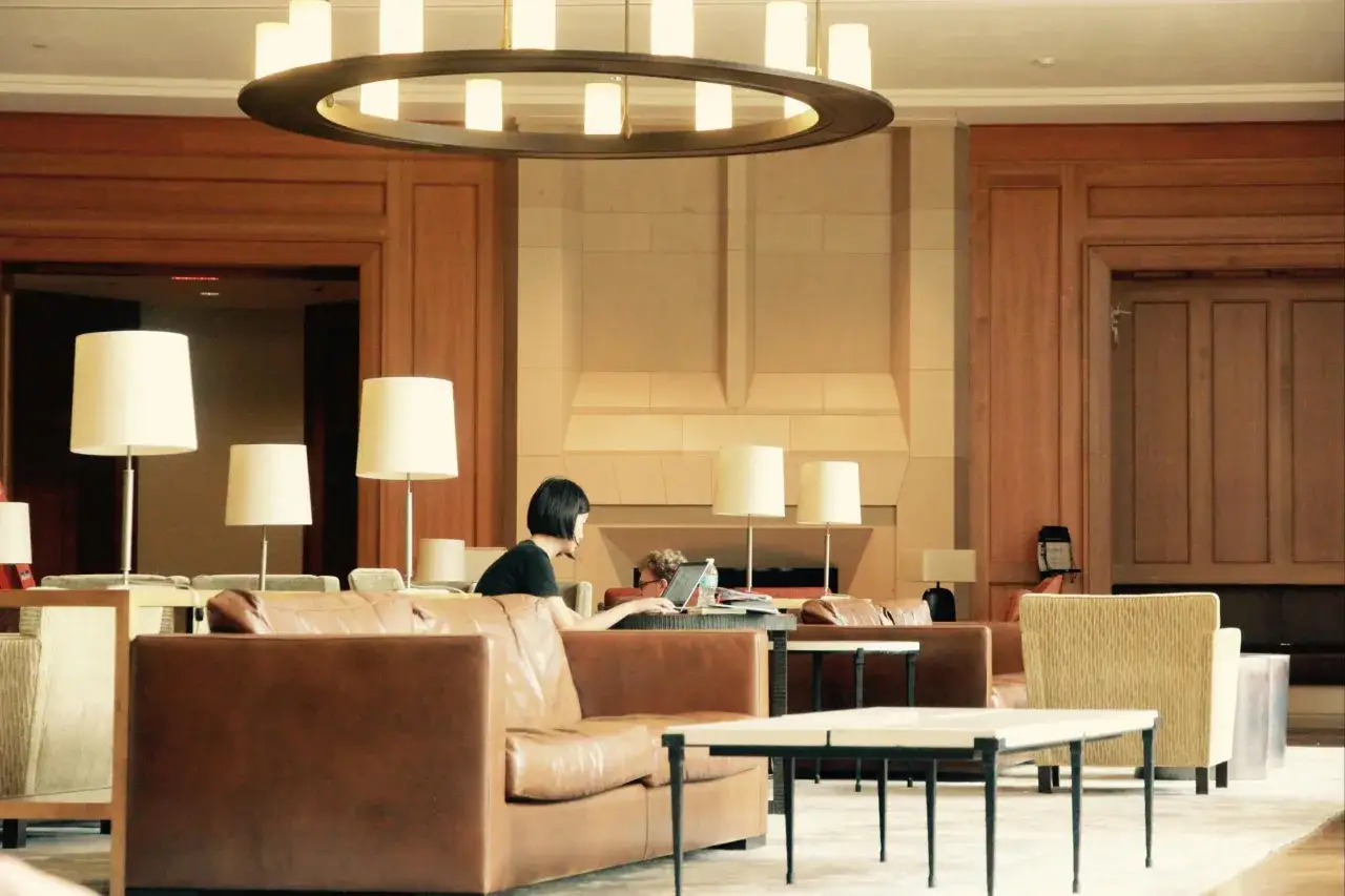 Wygodne fotele i kanapy w hotelowym lobby, gdzie można sprawdzić, ile trwa doba hotelowa, pracując na laptopie.