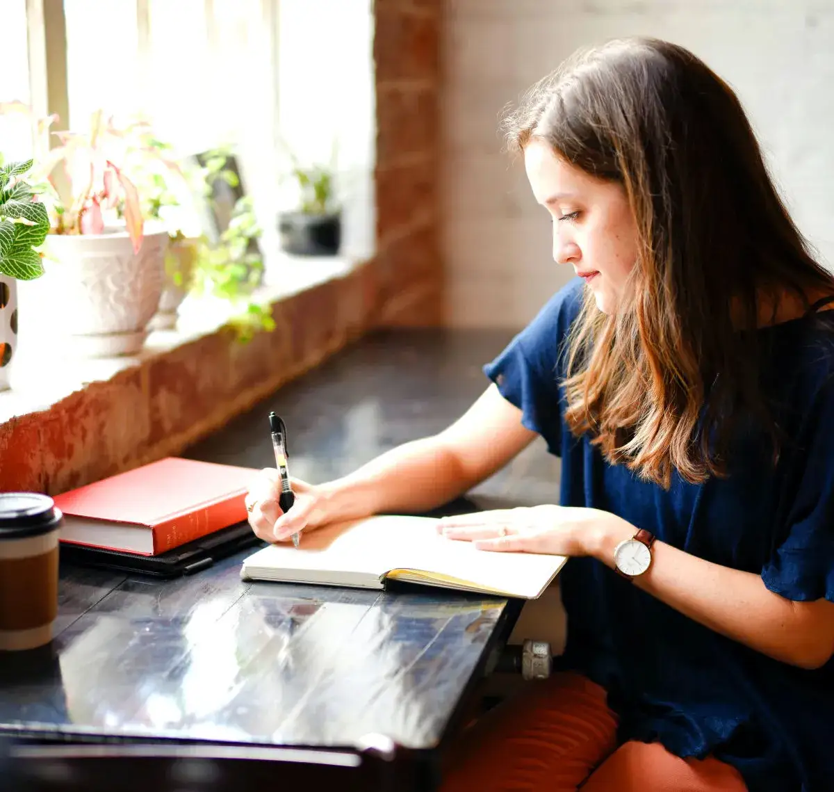 osoba pisząca w dzienniku, planująca cele, motywacja
