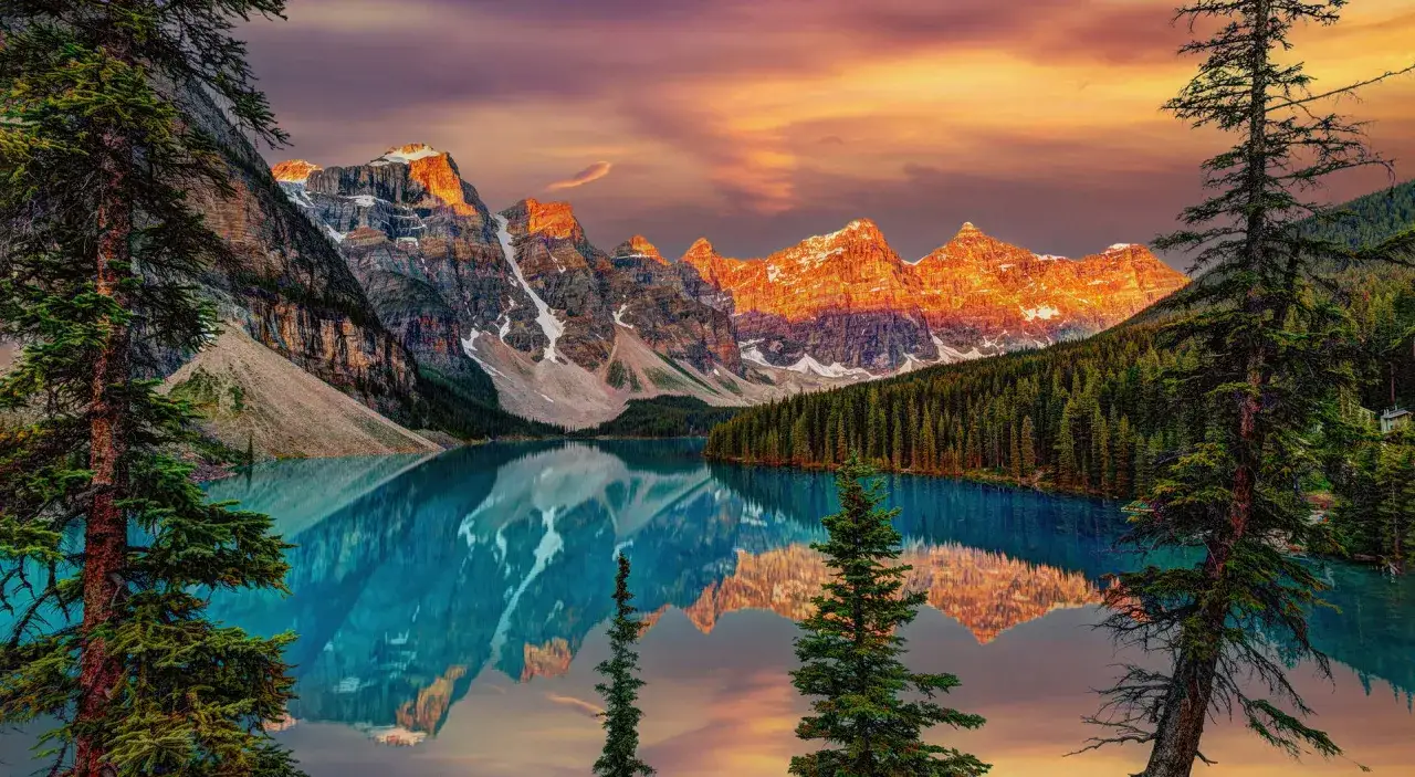 Kanada słynie z zapierających dech w piersiach krajobraz&oacute;w. Jezioro Moraine w Parku Narodowym Banff, otoczone ośnieżonymi szczytami i lasami, odbija się w turkusowej wodzie.