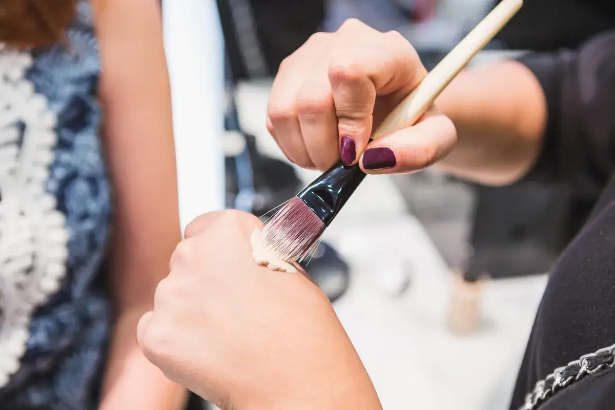 kobieta nakładająca krem bb palcami gąbką pędzlem