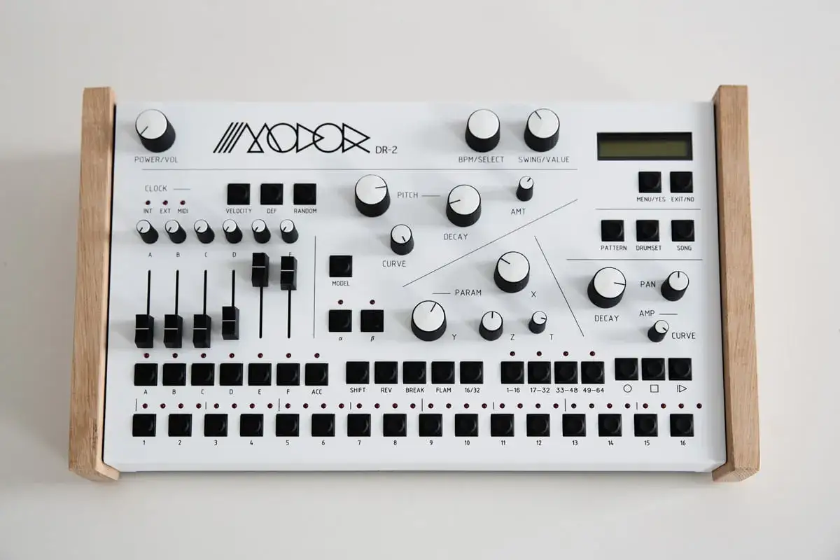 Biały automat perkusyjny dla gitarzysty, z drewnianymi bokami i mnóstwem pokręteł i przycisków do tworzenia rytmów.