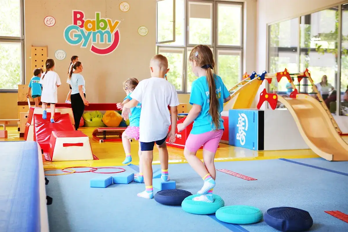 Dzieci klas 1-3 ćwiczą na sali gimnastycznej. Radosne gry i zabawy na torze przeszk&oacute;d, rozwijające koordynację i sprawność fizyczną.