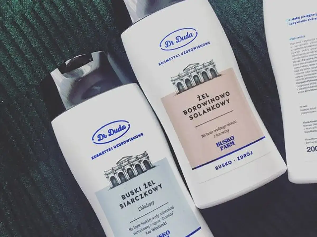 Dwa białe opakowania z kosmetykami Dr. Duda. Jedno z nich to żel borowinowo-solankowy, idealny do relaksującego masażu.