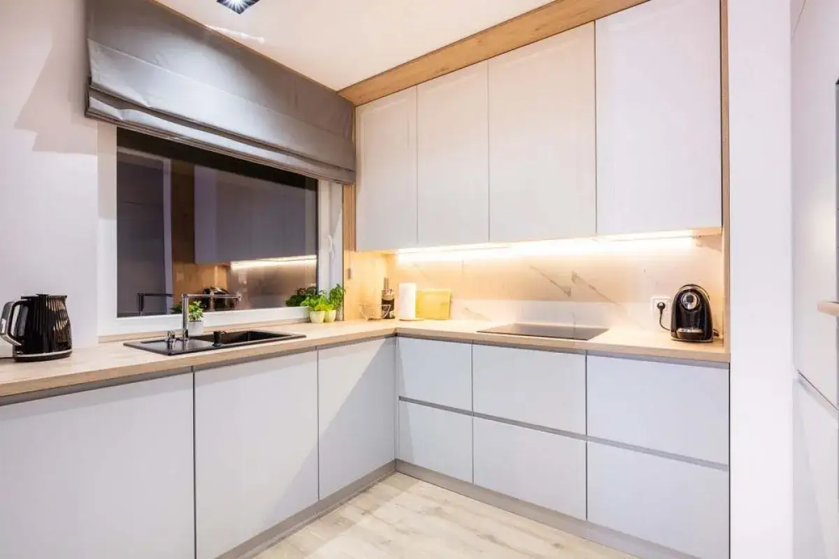 Cocina moderna con gabinetes blancos y encimeras de madera. Inspírate con nuestros catálogos de cocinas y precios para crear tu espacio ideal.