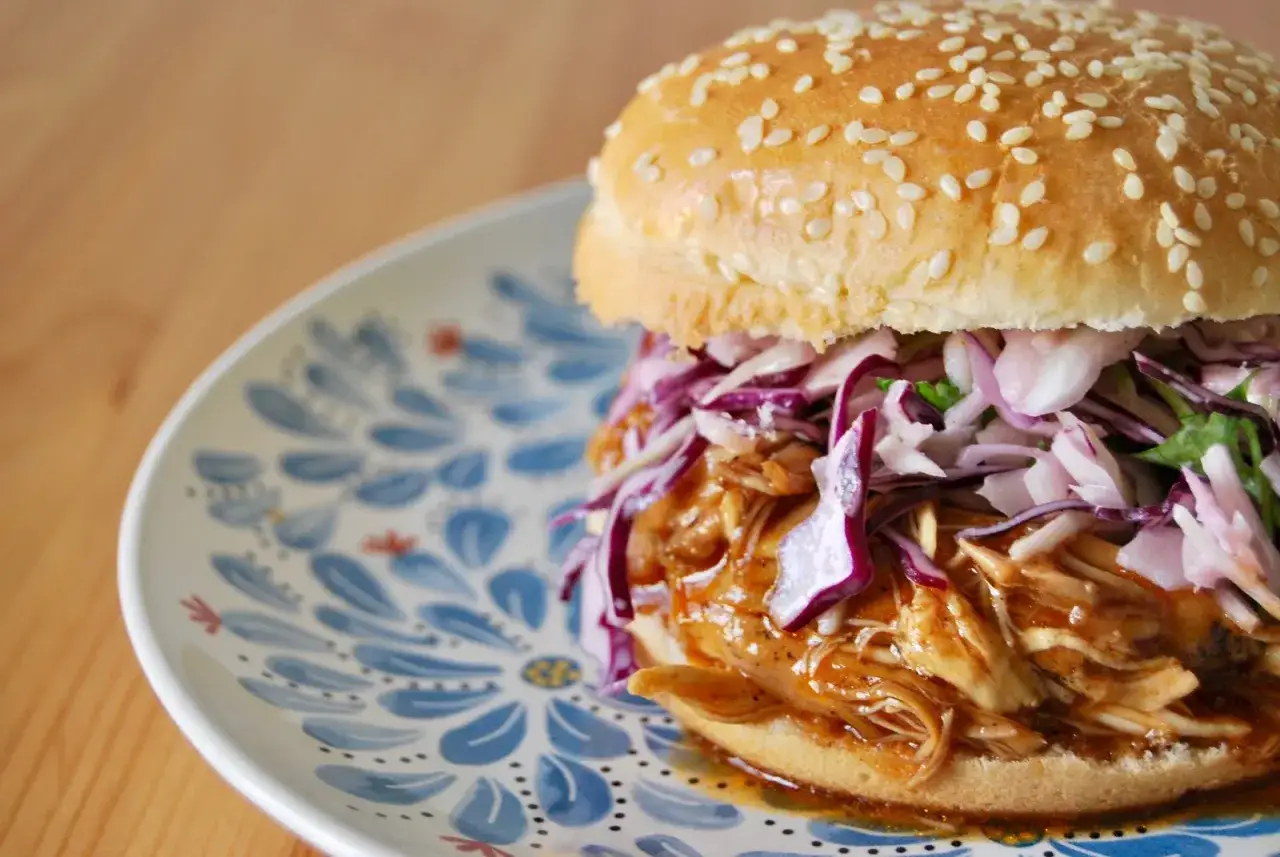 Gotowy burger z szarpaną wieprzowiną, coleslawem i piklami