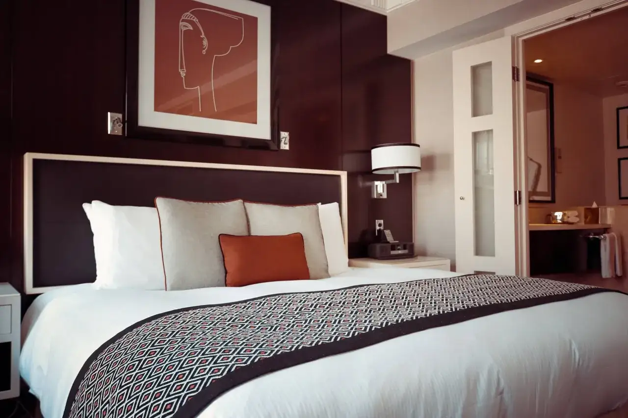 Przytulny pokój hotelowy z wygodnym łóżkiem, ozdobiony abstrakcyjnym obrazem. Luksusowy hotel, nie hostel.
