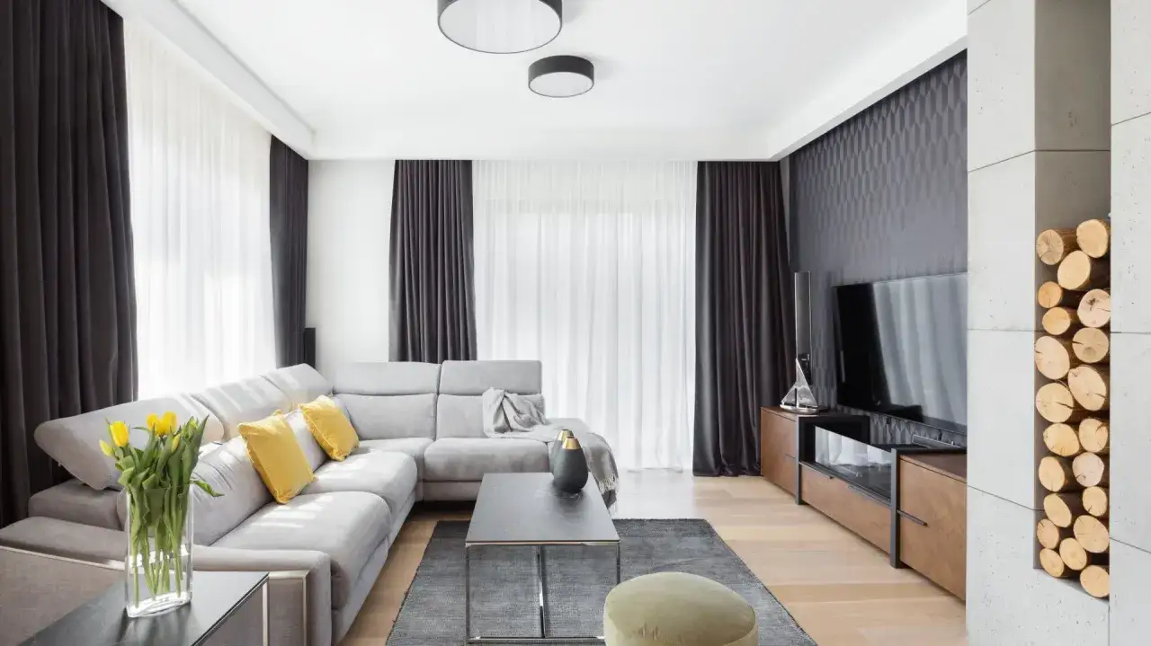 Nowoczesny salon z szarą sofą, żółtymi poduszkami i bukietem żółtych tulipanów. Eleganckie aranżacje wnętrza.