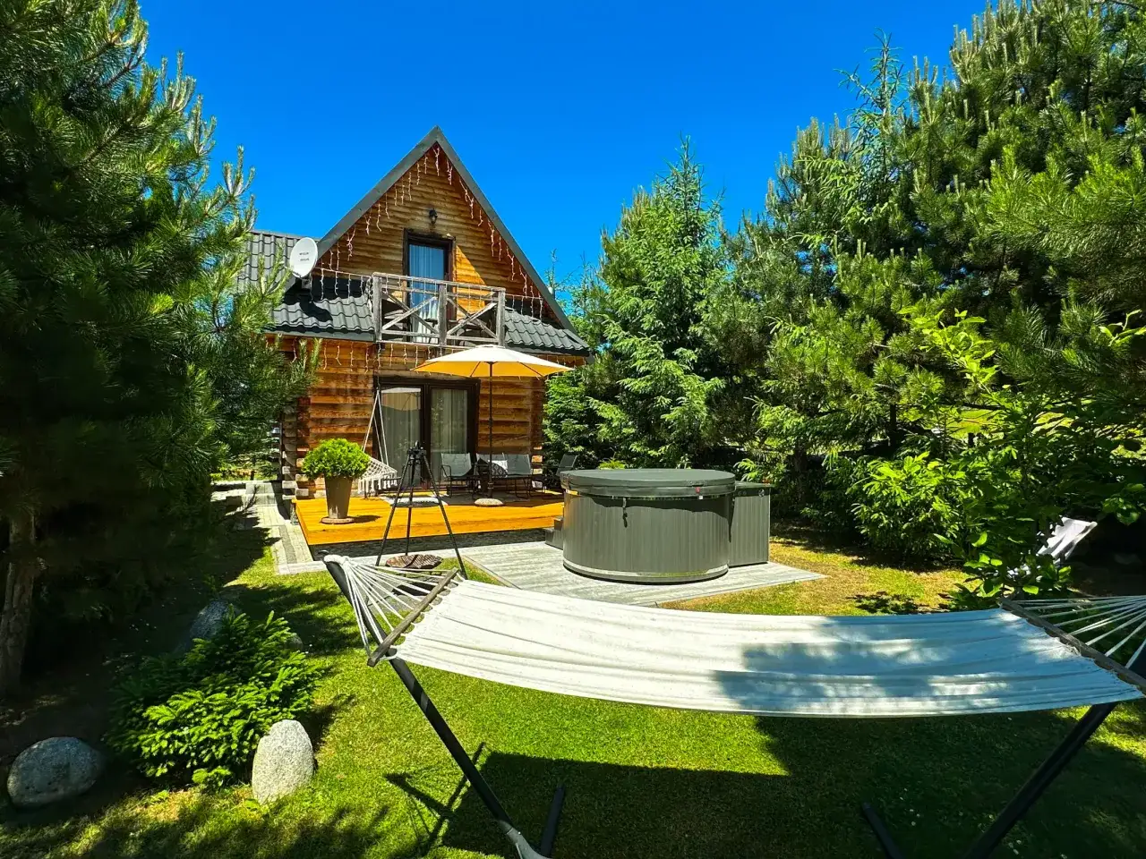 Drewniany domek w Bukowinie Tatrzańskiej otoczony zielenią, z tarasem, jacuzzi i hamakiem. Idealne miejsce na wypoczynek.