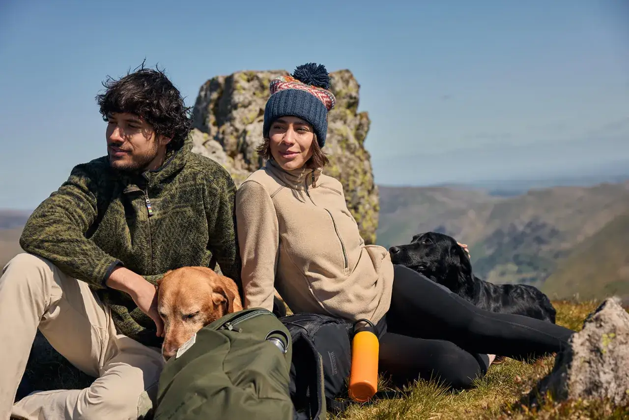 Para co to? Para w polarach i czapkach z psami na tle g&oacute;r.