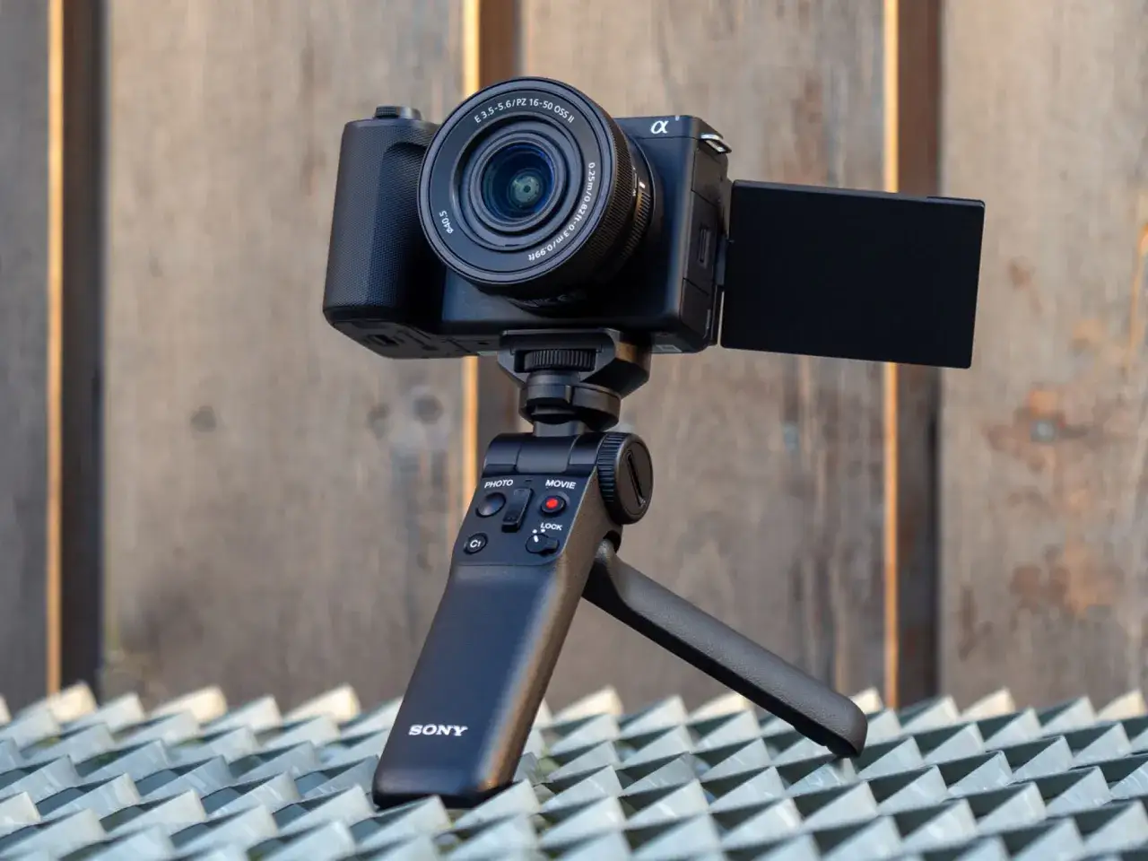 Sony ZV-E10 II z obiektywem PZ 16-50 mm na statywie z uchwytem, gotowy do nagrywania.