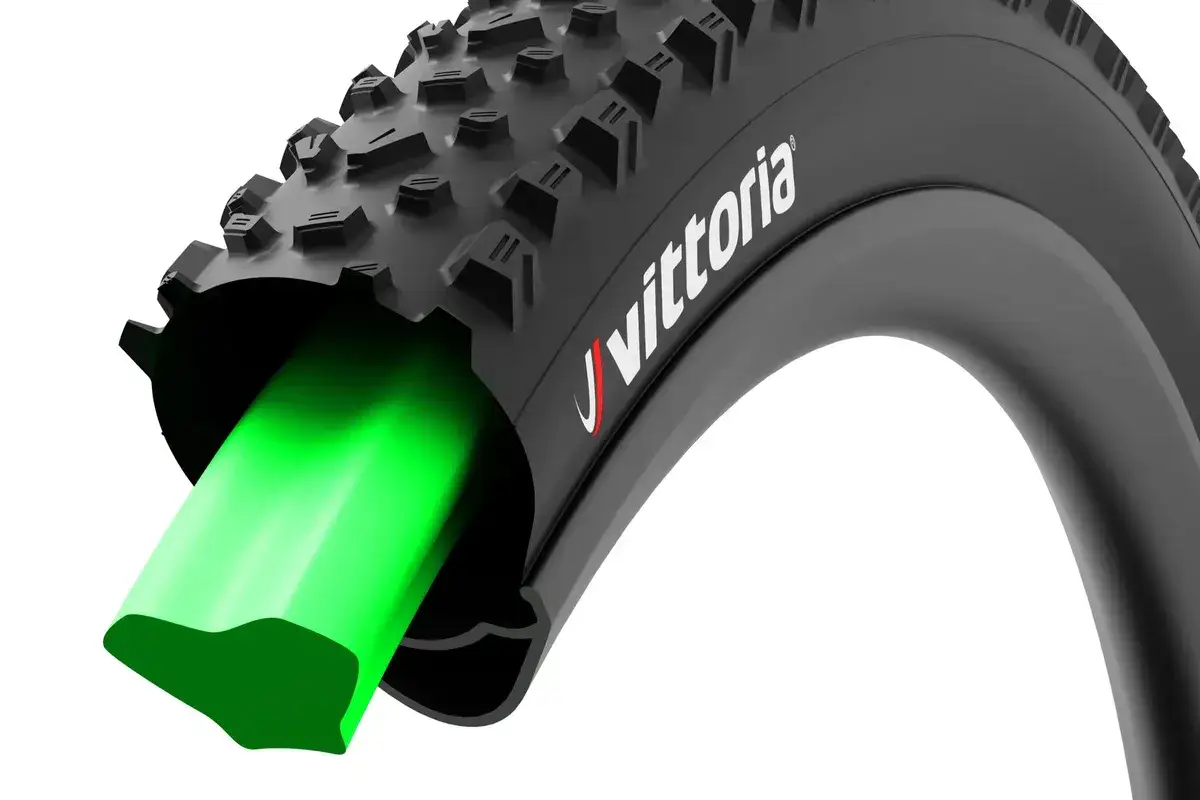 Zielona dętka w czarnej oponie rowerowej Vittoria. Idealne jakie ciśnienie w rowerze g&oacute;rskim zapewnia komfort i przyczepność.