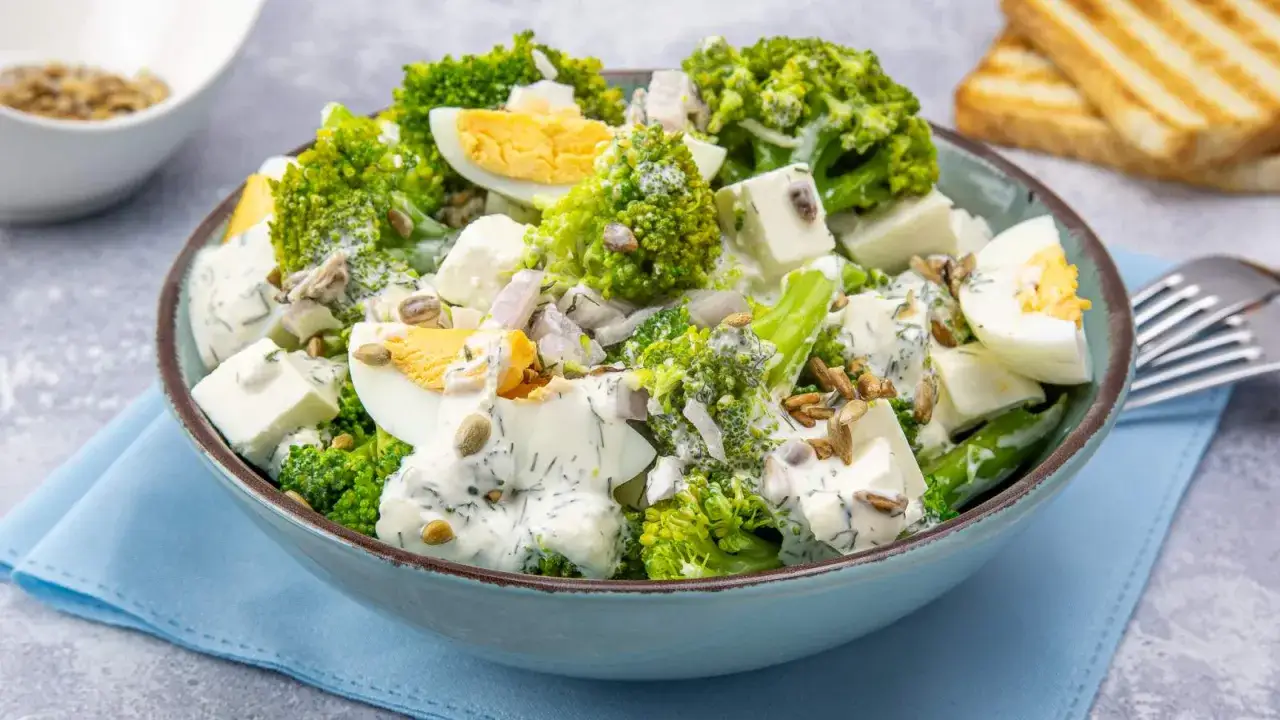 Pyszna sałatka z brokułem, jajkiem, pomidorem i słonecznikiem, polana kremowym sosem. Idealna na lekki posiłek.