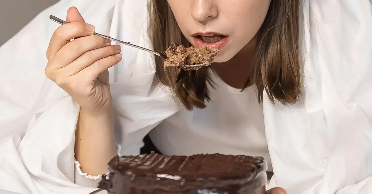 osoba zestresowana jedząca słodycze w ukryciu