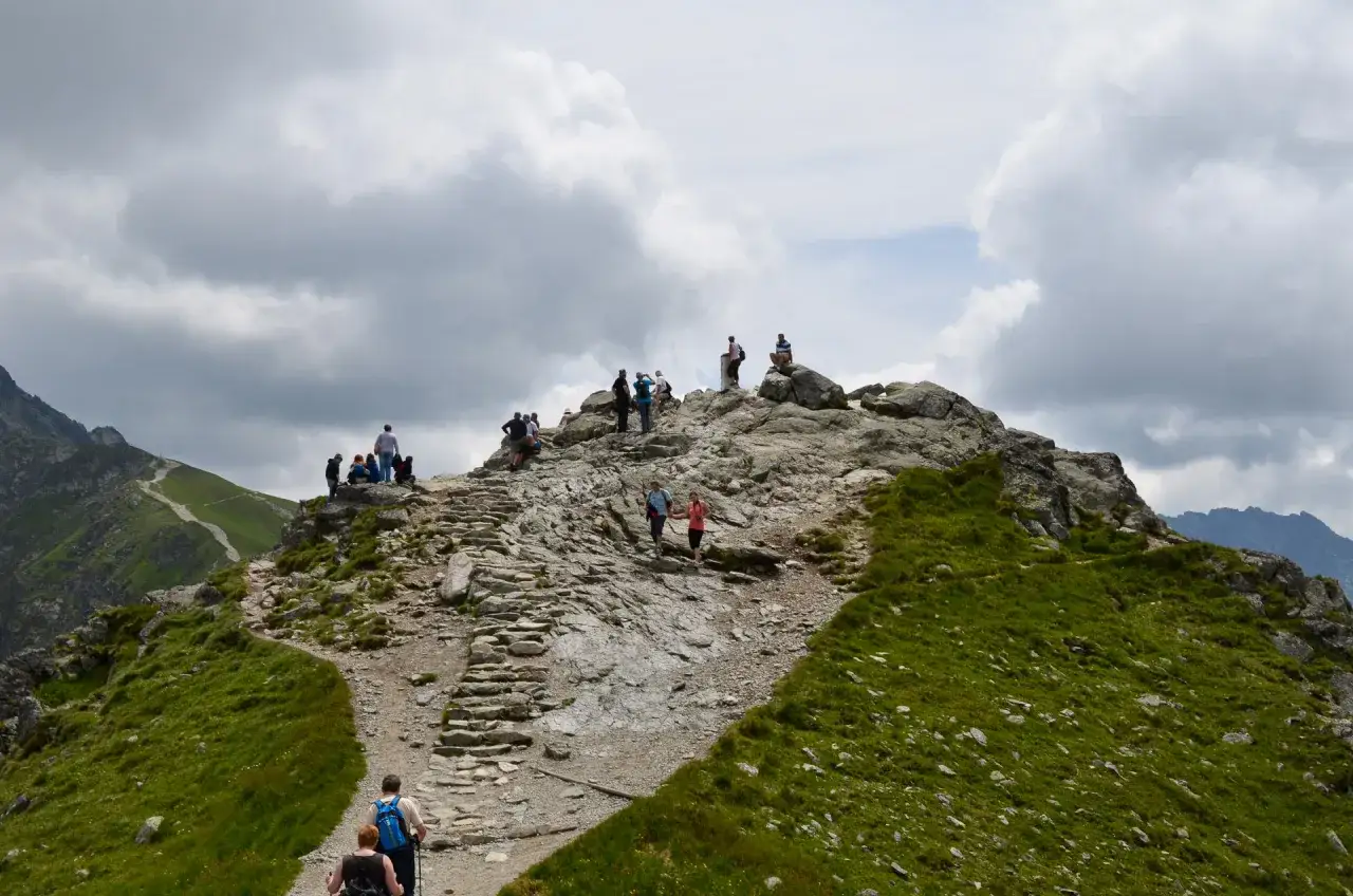 Tłum turystów na kamienistym szlaku na Kasprowy Wierch. Trasa na Kasprowy Wierch ma ok. 7 km.