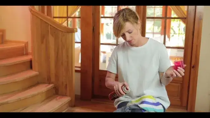 kobieta usuwająca plamę z długopisu z białej koszuli wacikiem