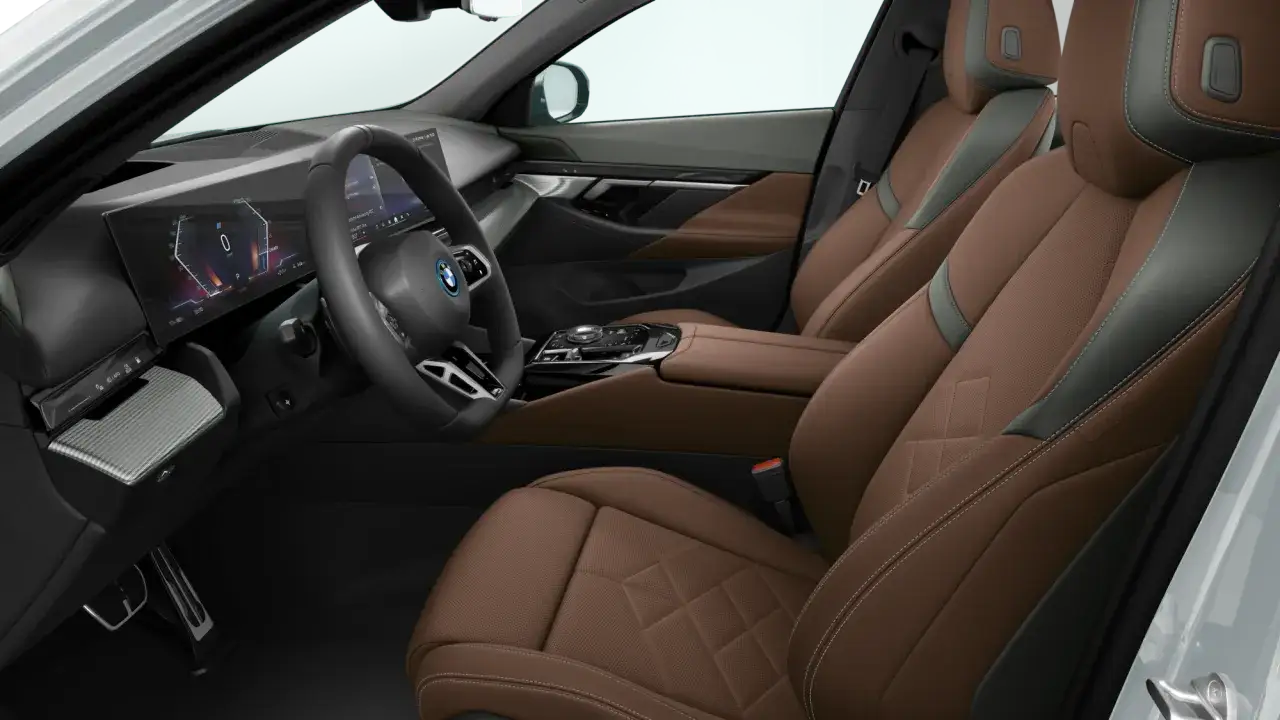 Wnętrze BMW Serii 5 z brązową skórzaną tapicerką, nowoczesnym panelem cyfrowym i kierownicą.