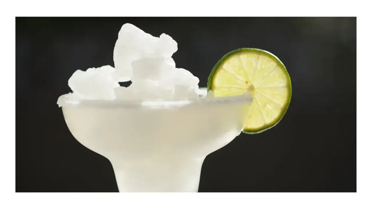 Mrożony napój z lodem, ozdobiony plasterkiem limonki, przypomina orzeźwiający lemon drop.