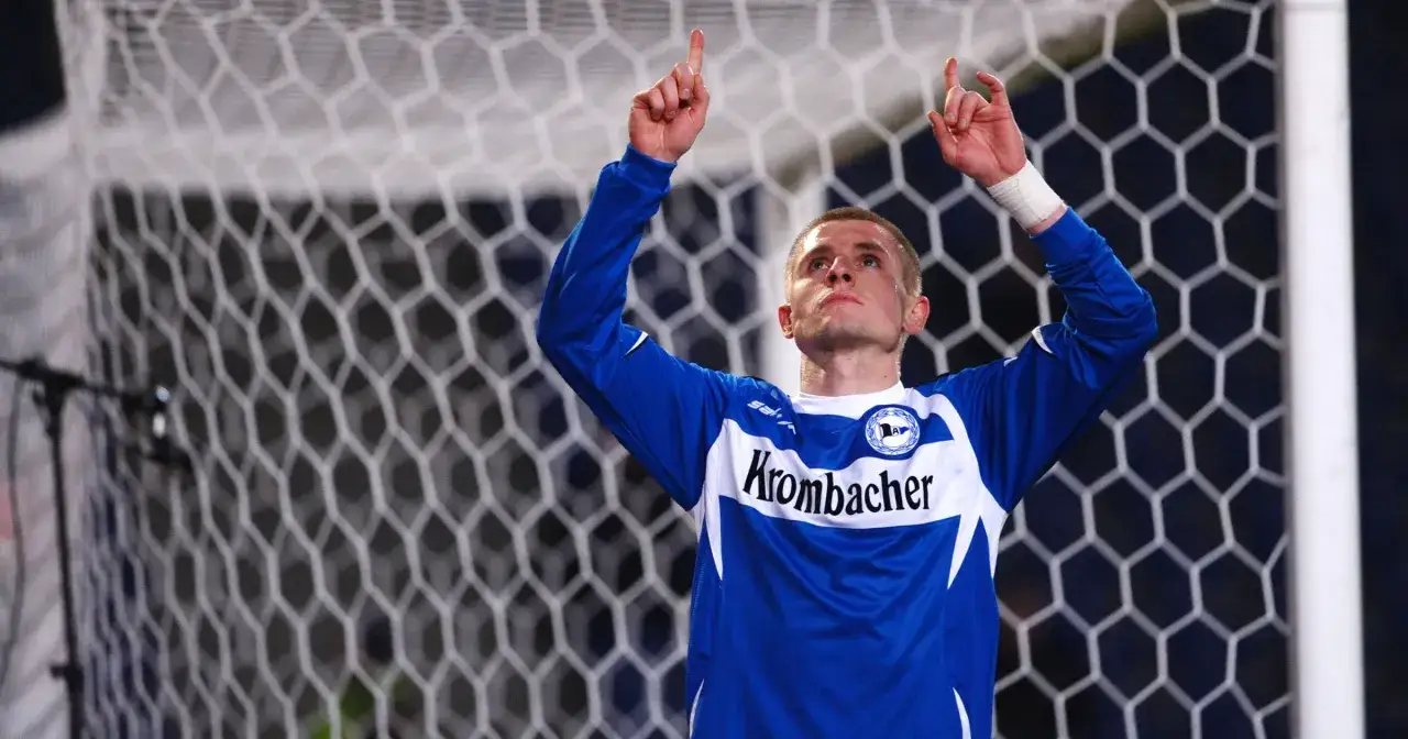 Piłkarz w niebieskiej koszulce z napisem 