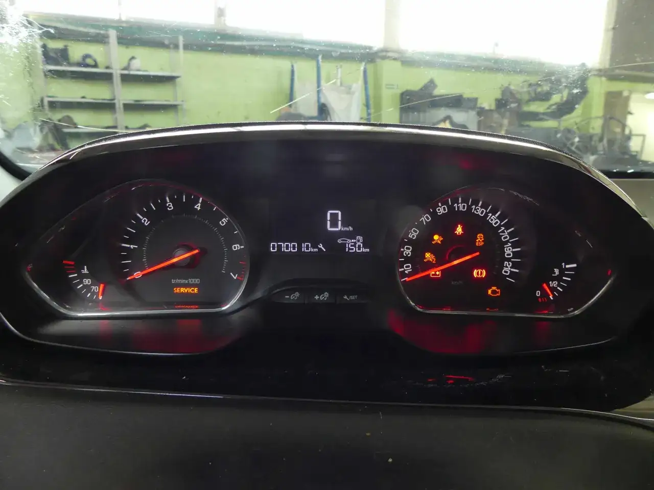 Deska rozdzielcza Peugeot 208 z zapalonymi kontrolkami: SERVICE, ESP, poduszki powietrzne, ciśnienie oleju. Opis kontrolek jest kluczowy.