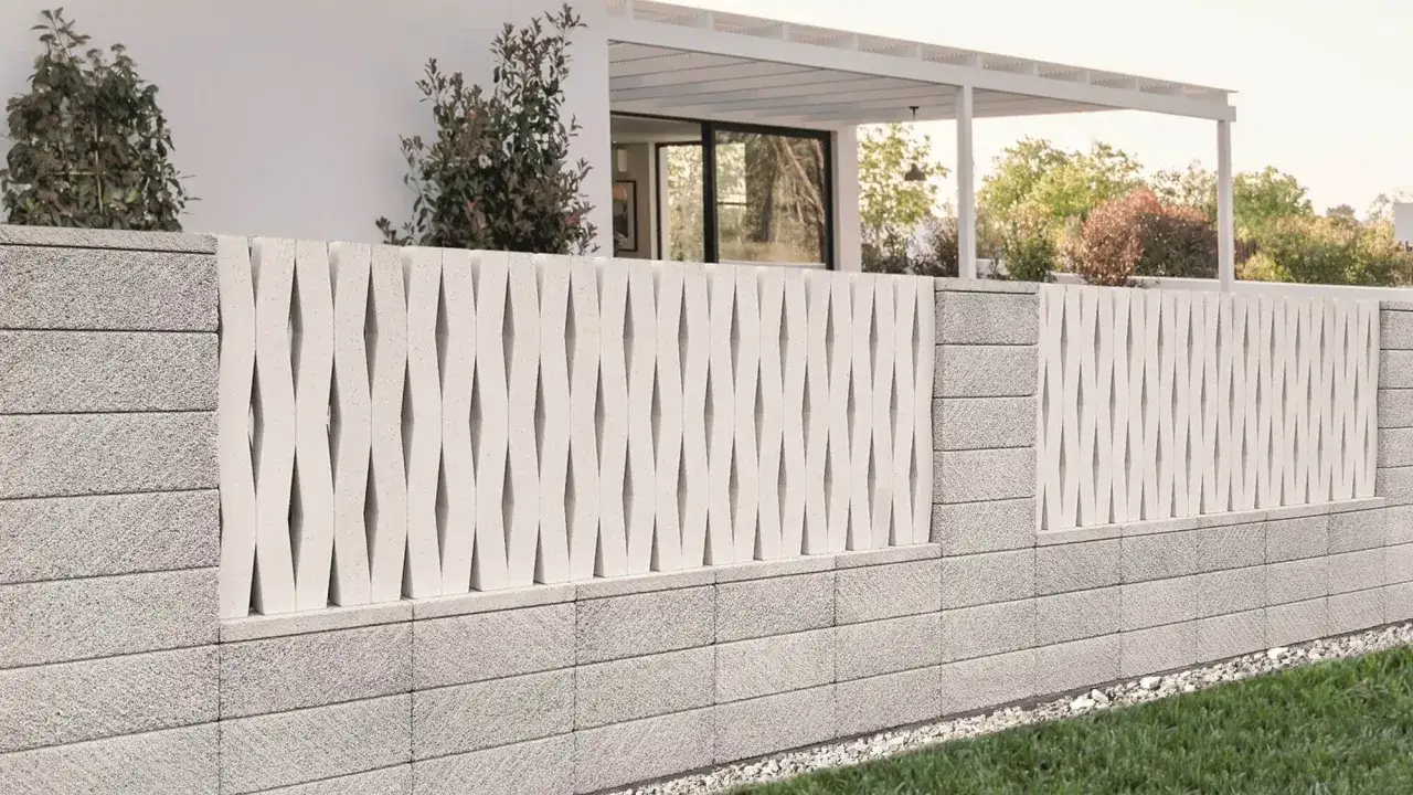 Nowoczesne ogrodzenie murowane pełne z ażurowym wzorem, otaczające dom z białym tarasem i zielonym ogrodem.