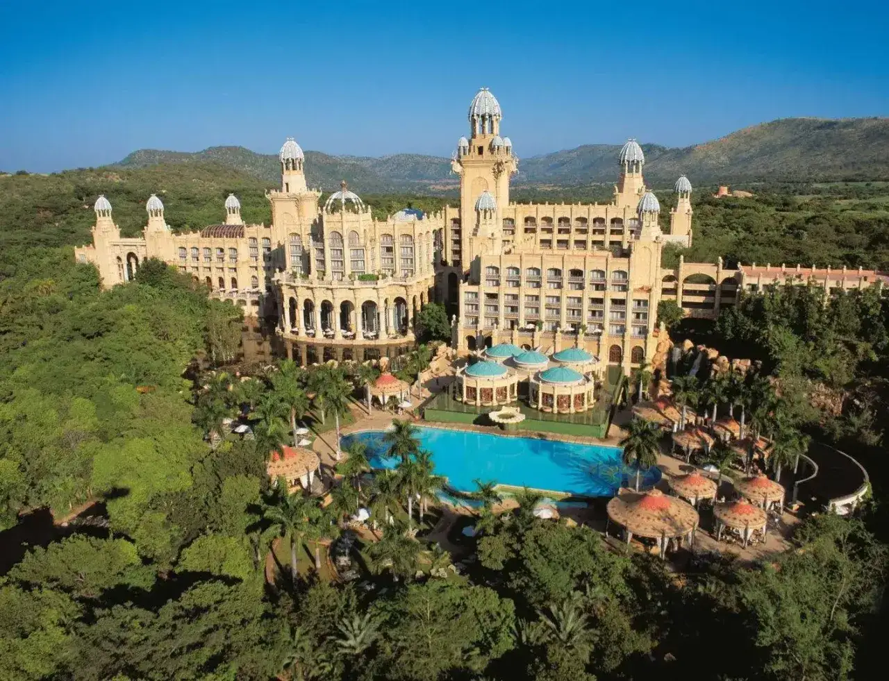 Majestatyczny hotel w Sun City, RPA, otoczony bujną zielenią i basenem.