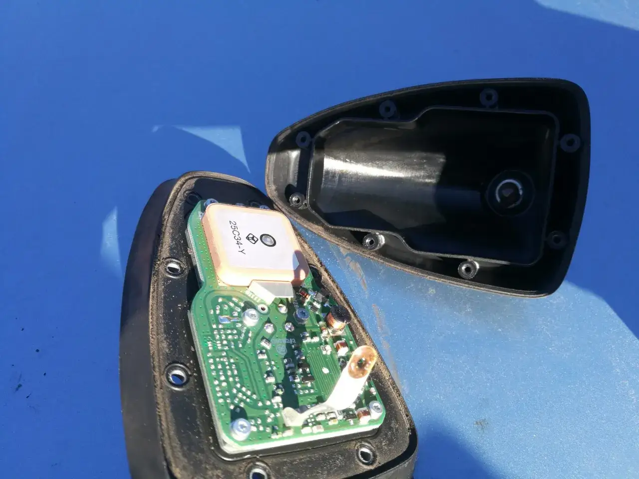 Rozkręcona antena samochodowa z widoczną płytką drukowaną i modułem GPS. Może to być powód, dlaczego radio nie odbiera stacji.