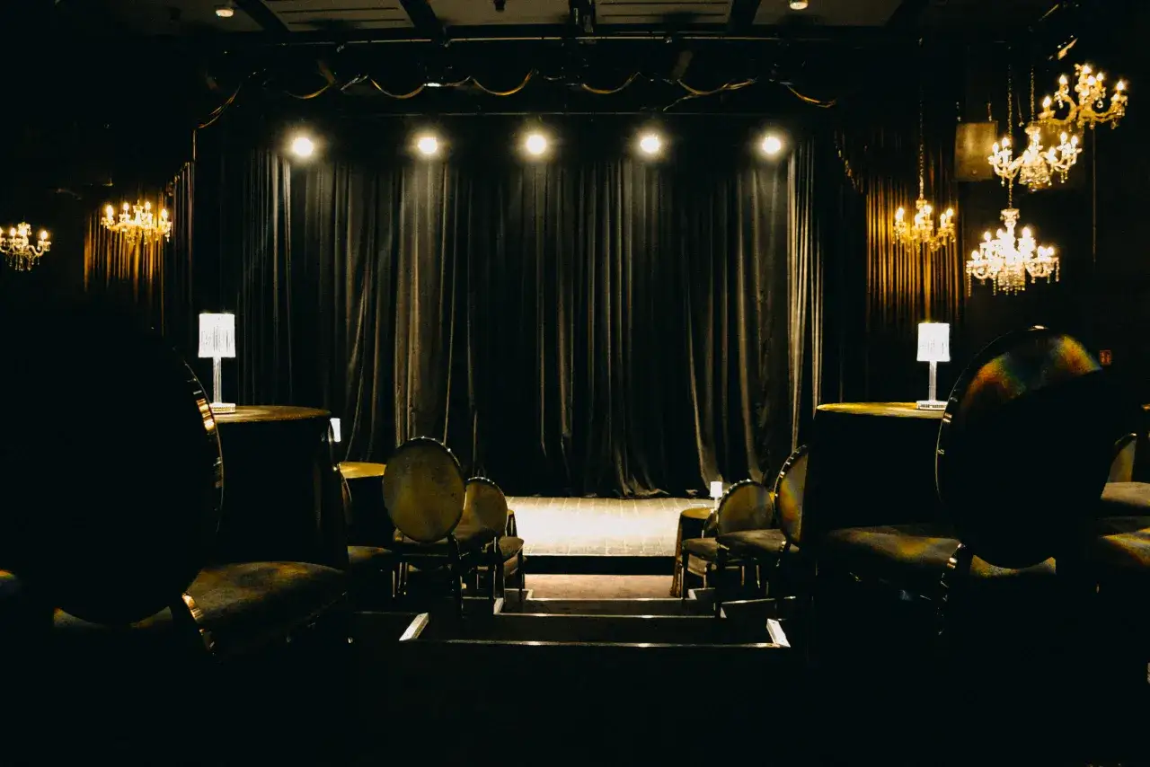 Kameralna scena z welurowymi zasłonami, żyrandolami i pustymi miejscami. Takie teatry w Warszawie czekają na widz&oacute;w.
