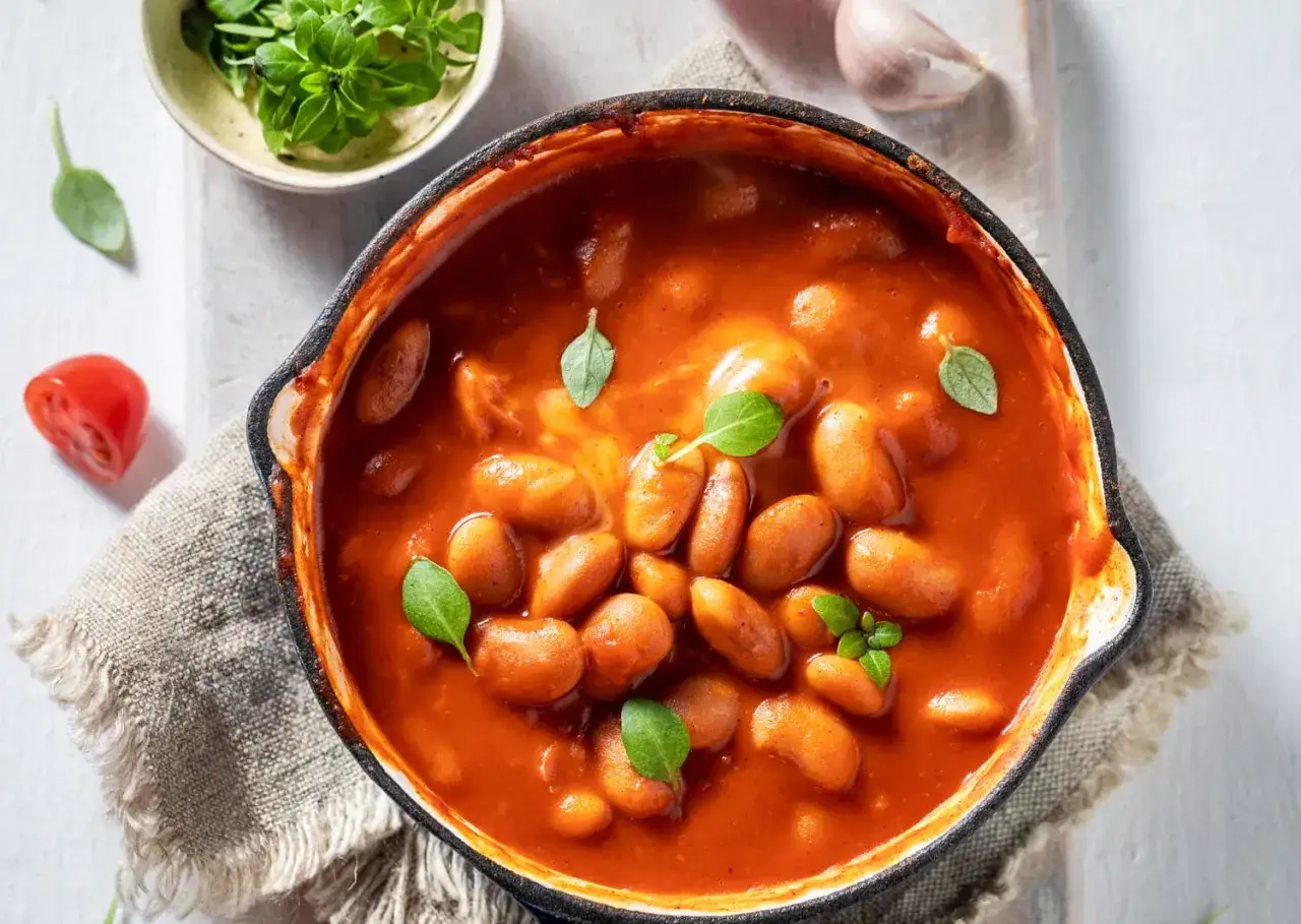 Pyszna zupa fasolowa w sosie pomidorowym, ozdobiona listkami bazylii. Zastanawiasz się, ile kalorii ma talerz zupy fasolowej?