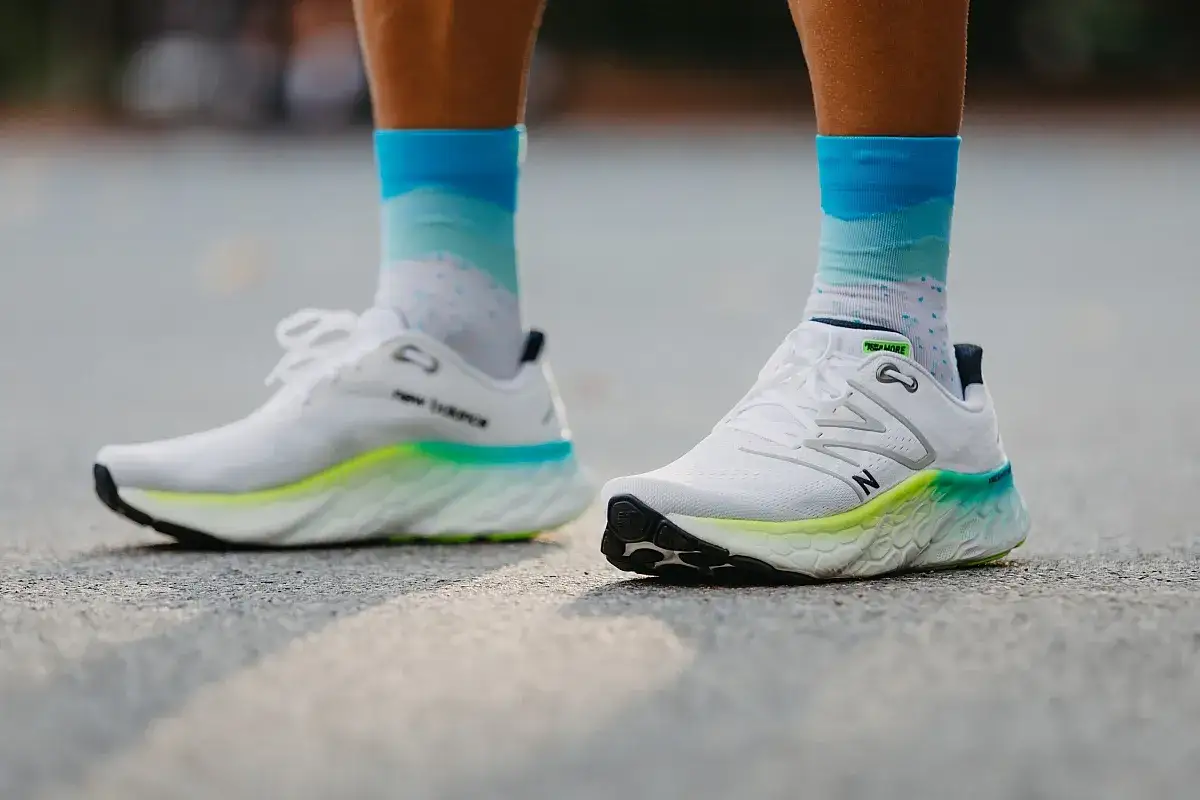 Biegacz w białych butach New Balance i kolorowych skarpetkach. Czy buty do biegania powinny być większe? Zobacz, jak wyglądają na nogach.