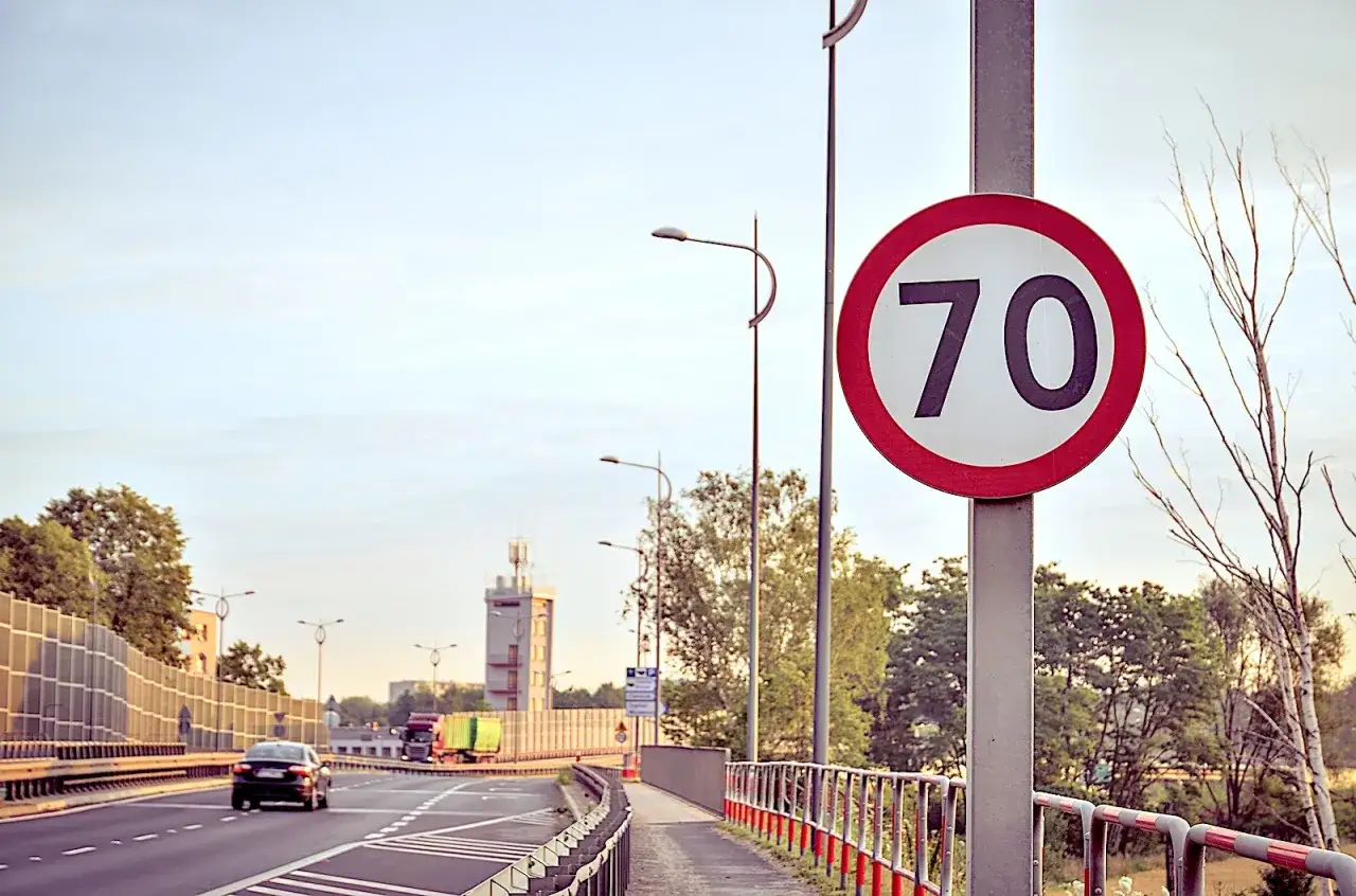 Znak ograniczenia prędkości 70 km/h. Warto pamiętać, ile można jechać w terenie niezabudowanym, by bezpiecznie dotrzeć do celu.