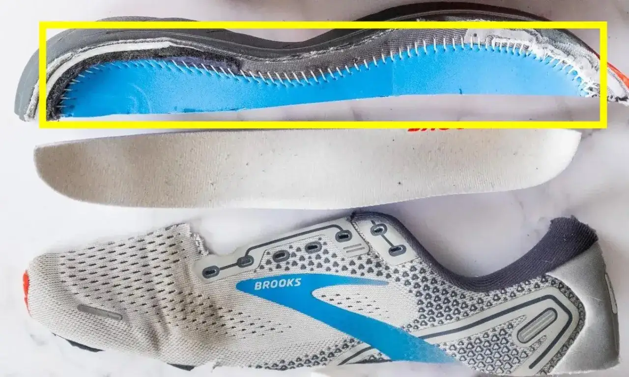 Widok przekroju buta sportowego Brooks. Widoczna niebieska pianka amortyzująca wewnątrz cholewki buta, pod wkładką.