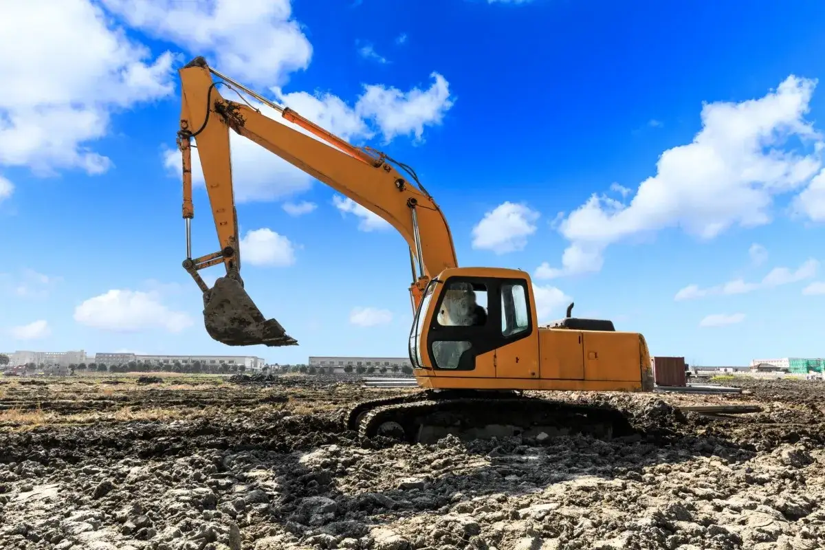 Żółta koparka na placu budowy. Zastanawiasz się, ile zarabia operator koparki?