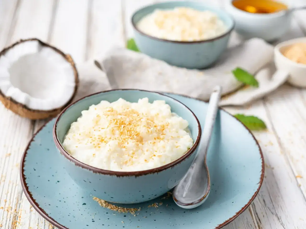 Pyszny ryż z kokosem, idealny pomysł na to, co zrobic z ryzem po ugotowaniu. Podany w błękitnej miseczce, posypany wi&oacute;rkami.