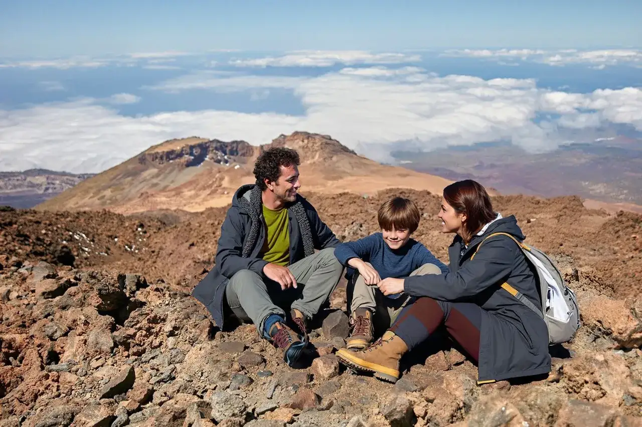 Rodzina odpoczywa na wulkanicznym krajobrazie. Wejście na wulkan Teide zajmuje kilka godzin, a na szczyt potrzebne jest zezwolenie.