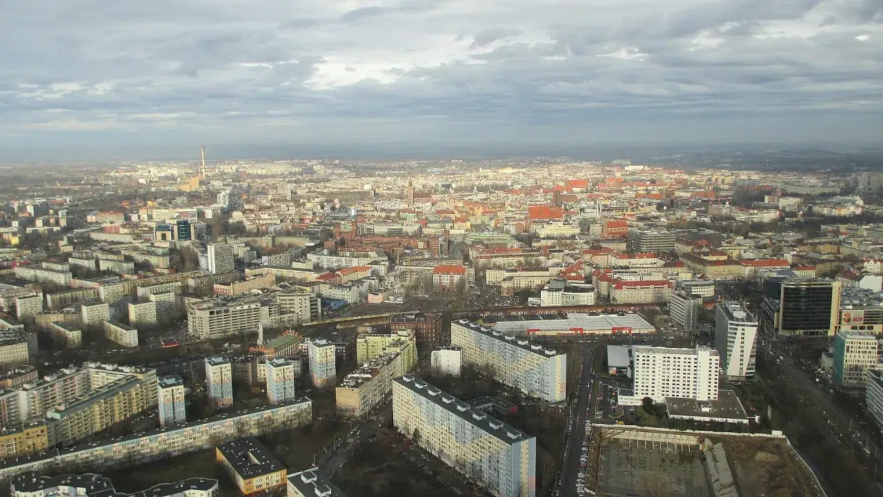 Widok na Wrocław z lotu ptaka, z widocznym kominem, który jest najwyższym budynkiem we Wrocławiu, otoczonym przez zabudowania miejskie.