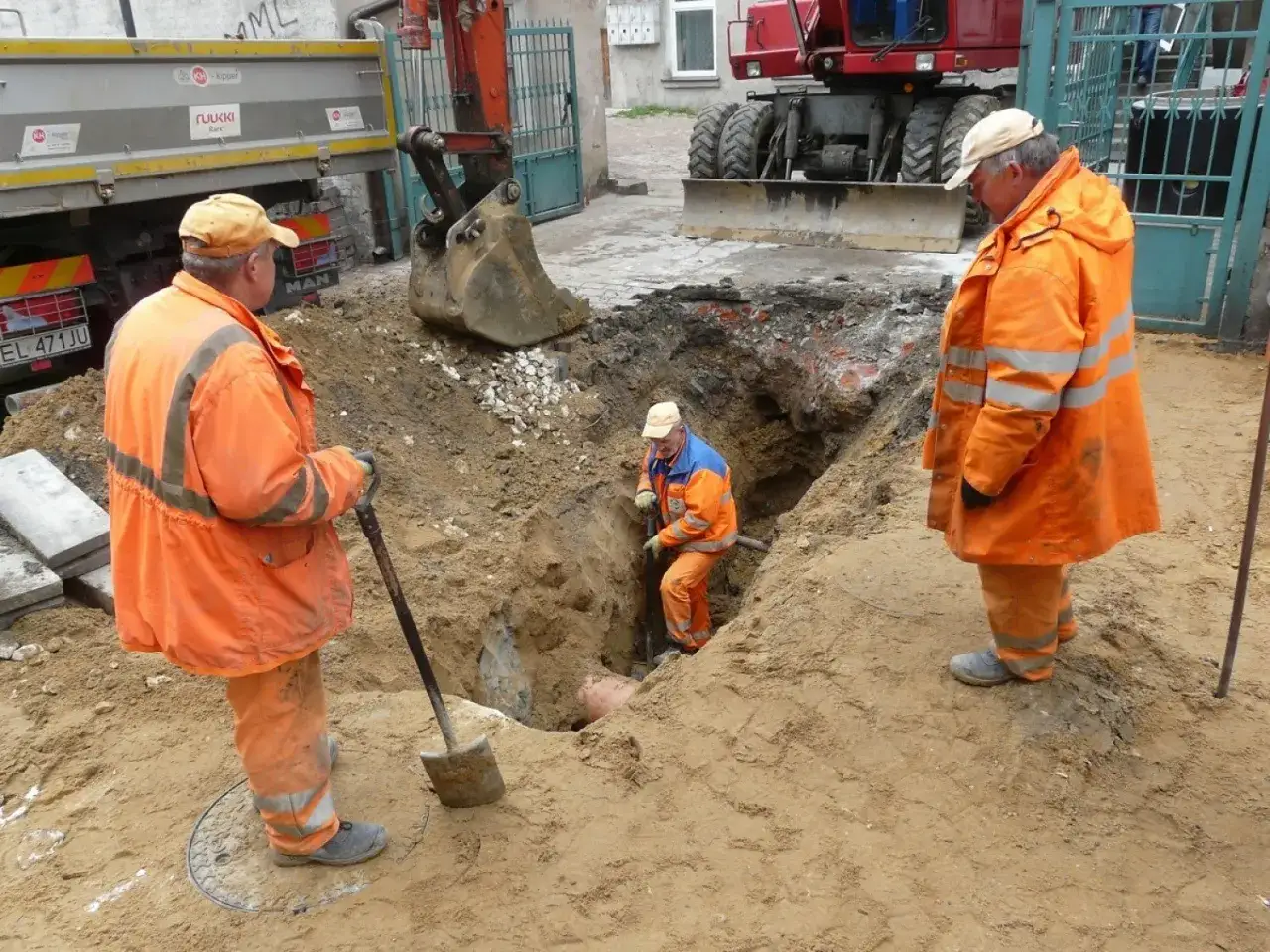 Trzej pracownicy w pomarańczowych strojach kopią rów. Kto odpowiada za rury przed licznikiem? To oni, bo pracują przy infrastrukturze.