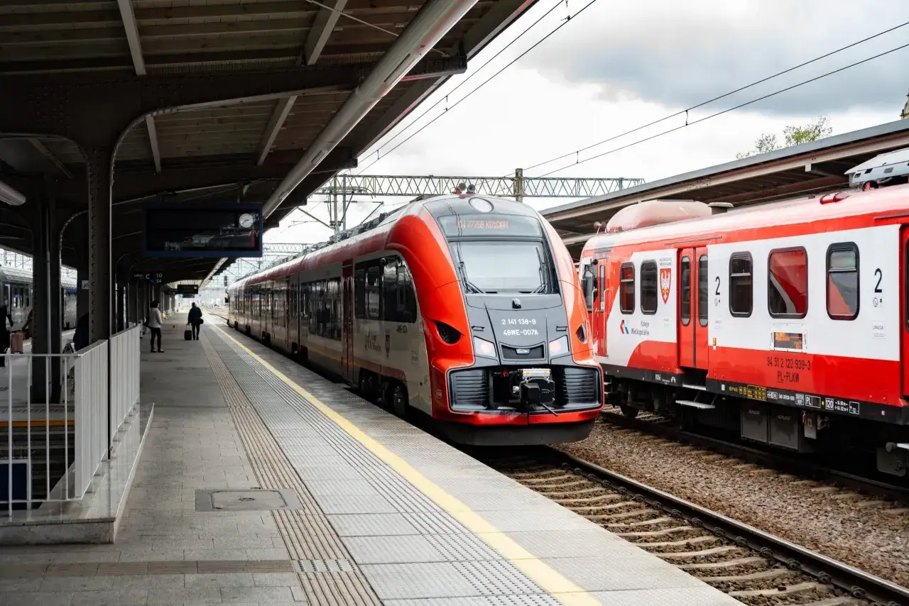 Nowoczesny pociąg Kolei Wielkopolskich na peronie, gotowy do podróży z Olsztyna do Warszawy.