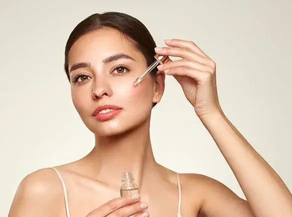 kobieta nakładająca serum na twarz, pielęgnacja cery trądzikowej