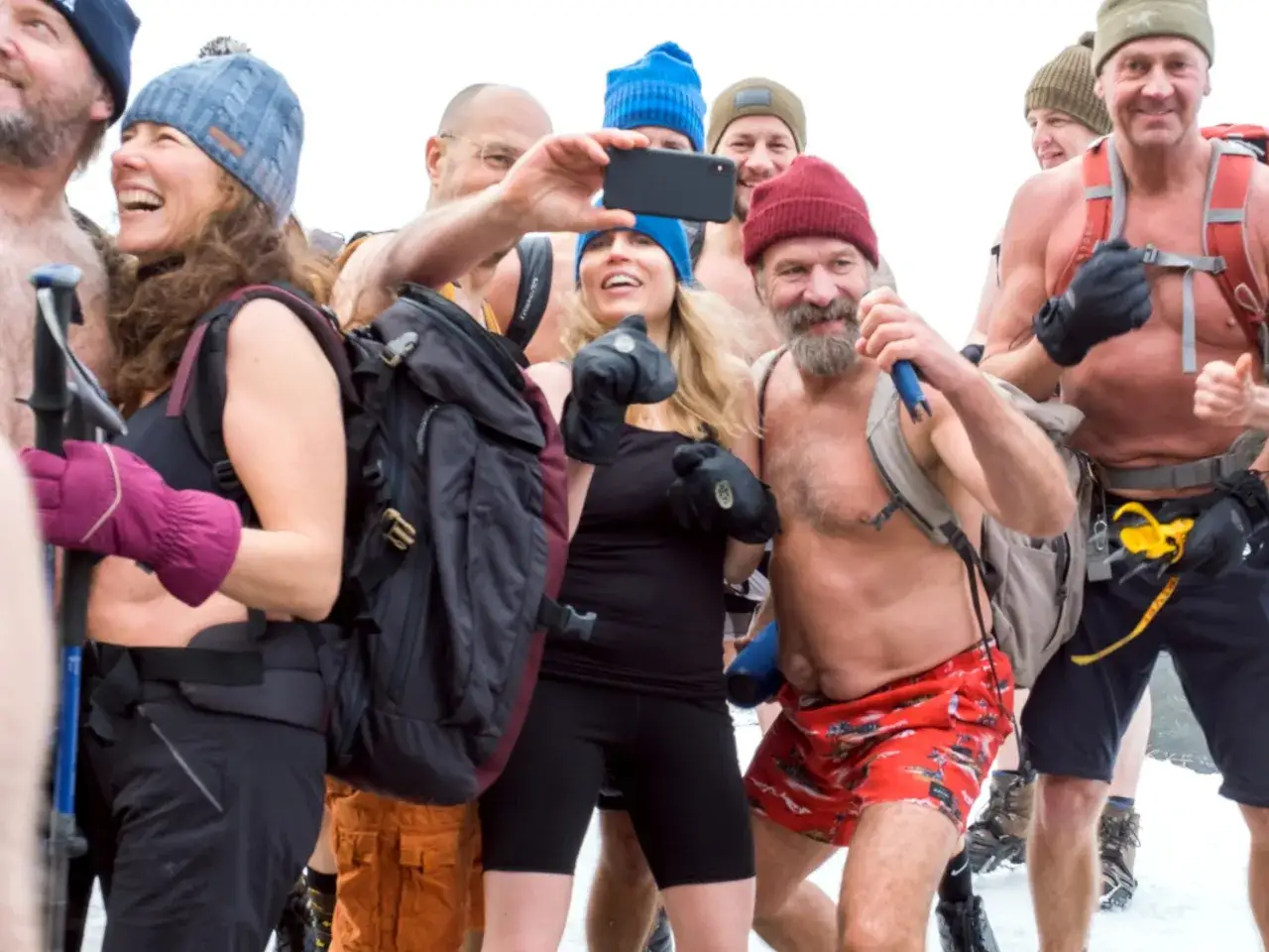 Grupa entuzjastów morsowania, być może w ramach akcji Wim Hof Polska, pozuje do zdjęcia. Uśmiechnięci, w czapkach i rękawiczkach, niektórzy z plecakami.