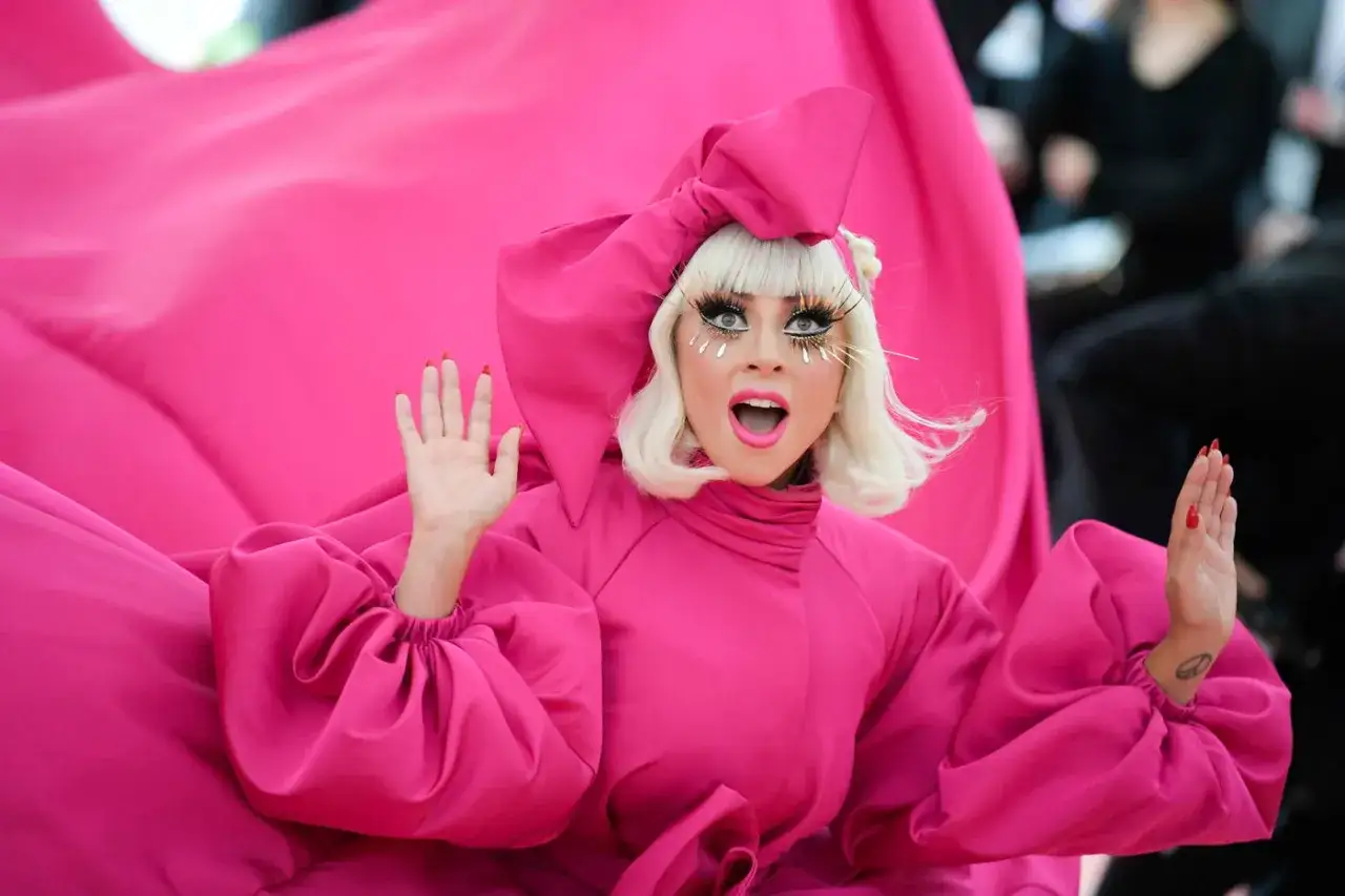 Lady Gaga w olśniewającej r&oacute;żowej kreacji na Met Gala, z teatralnym makijażem i falującą tkaniną.