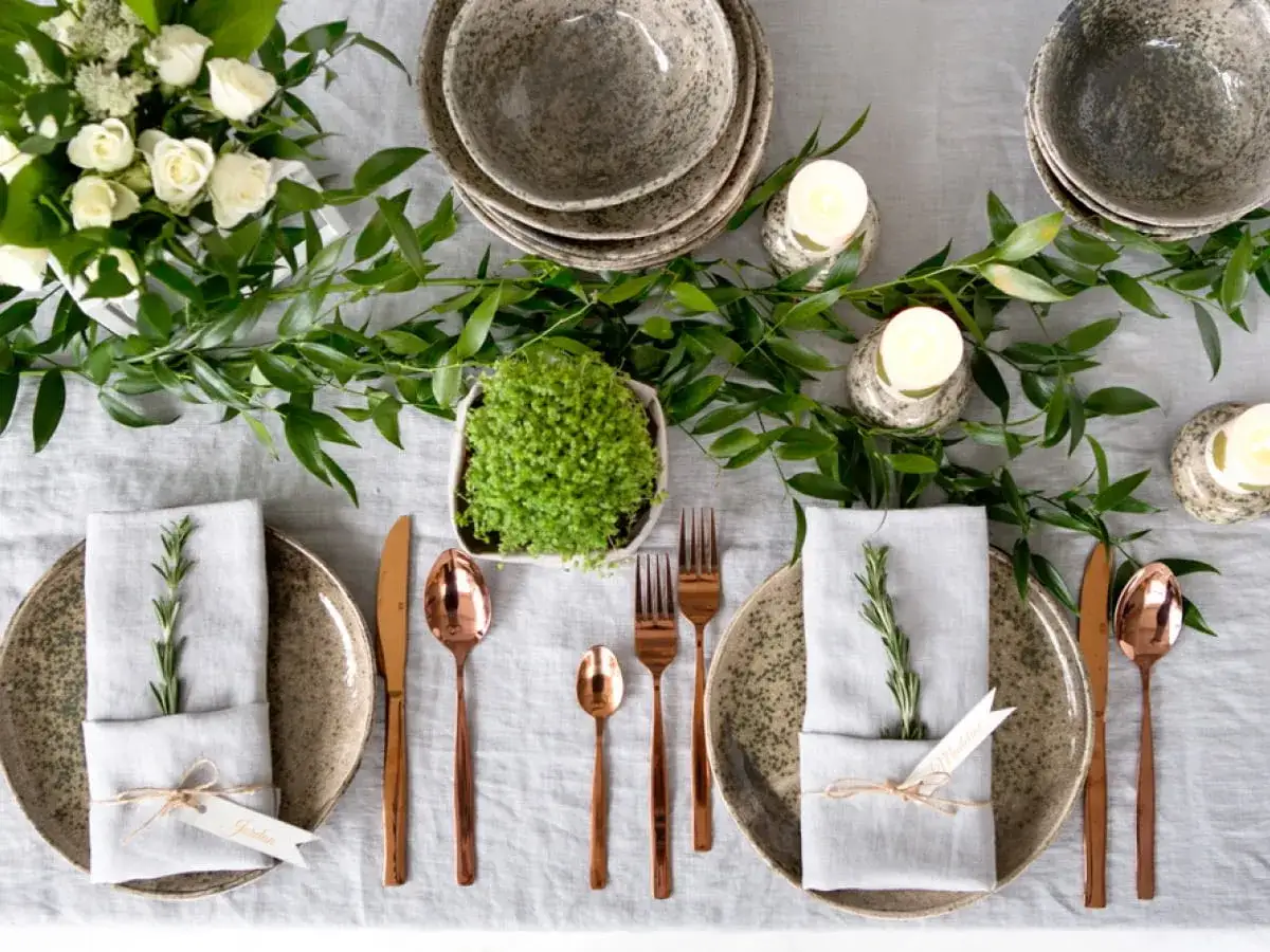 Elegancko nakryty st&oacute;ł na Wielkanoc. Zastanawiasz się, co na obiad wielkanocny? Bukiet białych r&oacute;ż, świece i zielone gałązki tworzą świąteczną atmosferę.