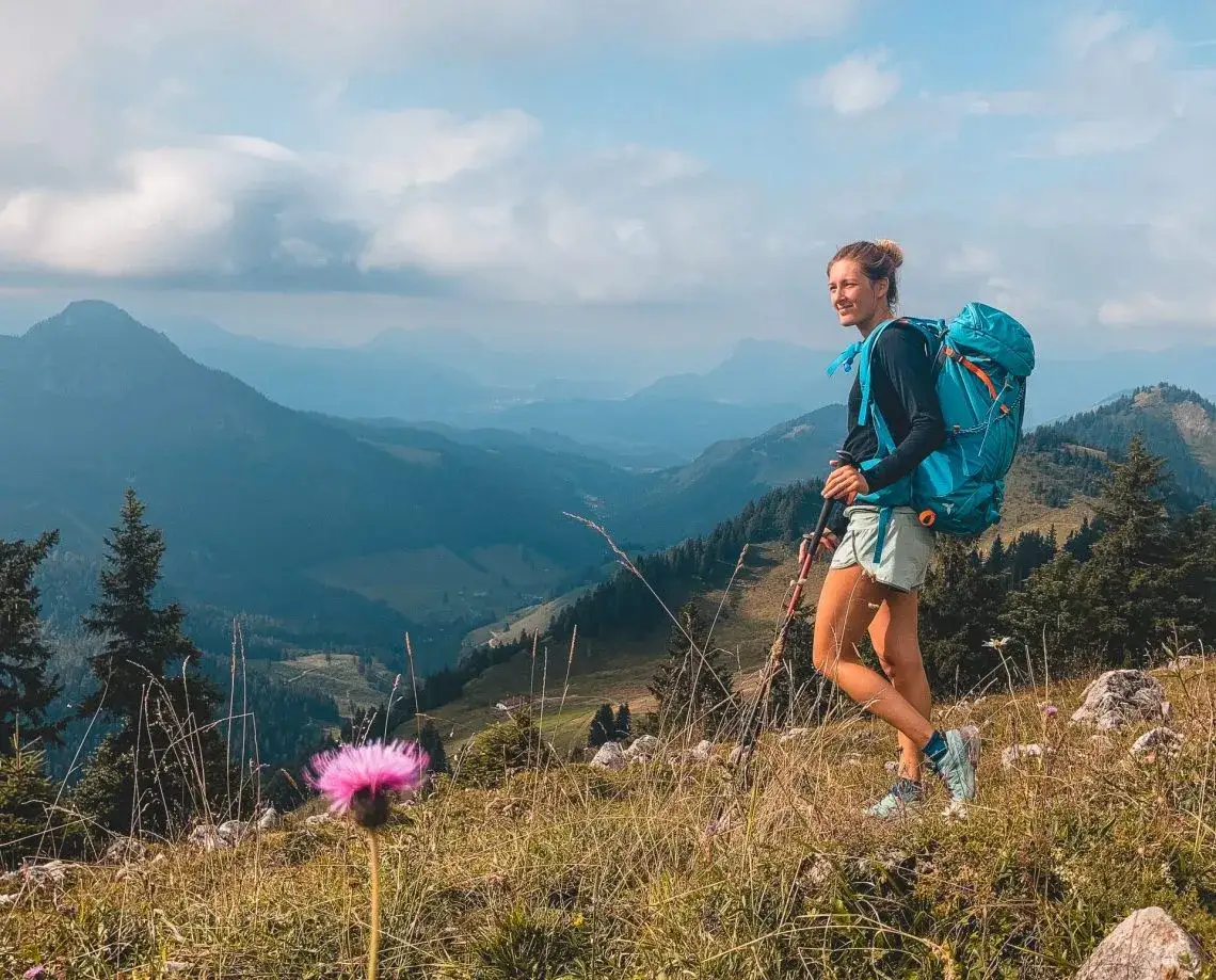 Wanderer mit Rucksack und Wanderschuhen vor Bergkulisse