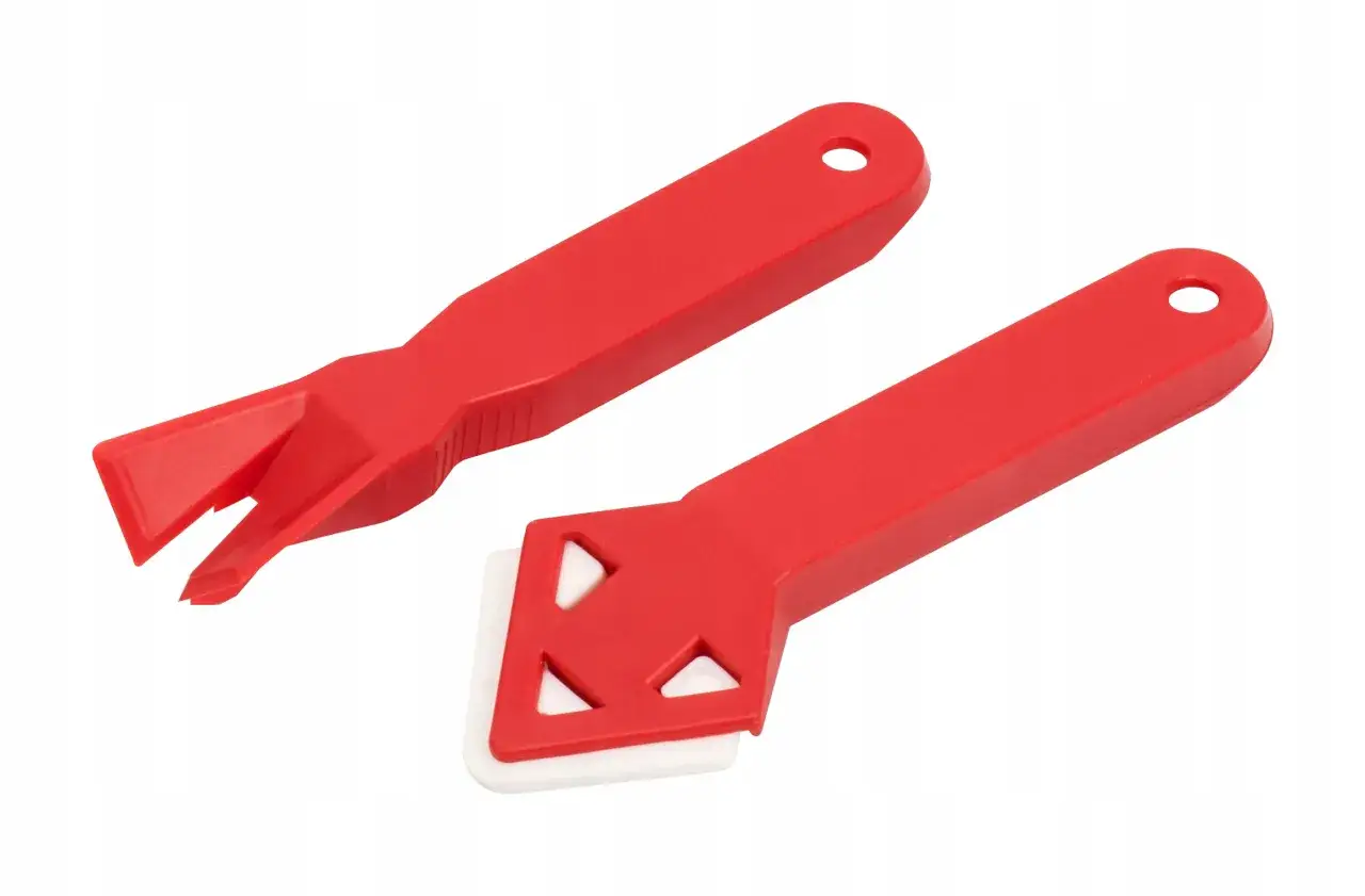 Dwa czerwone narzędzia do silikonowania. Jedno z nich ma białą, gumową końcówkę do wygładzania, drugie zaś rozwidloną do usuwania starego silikonu. Pozwalają na precyzyjne nakładanie silikonu warstwami.