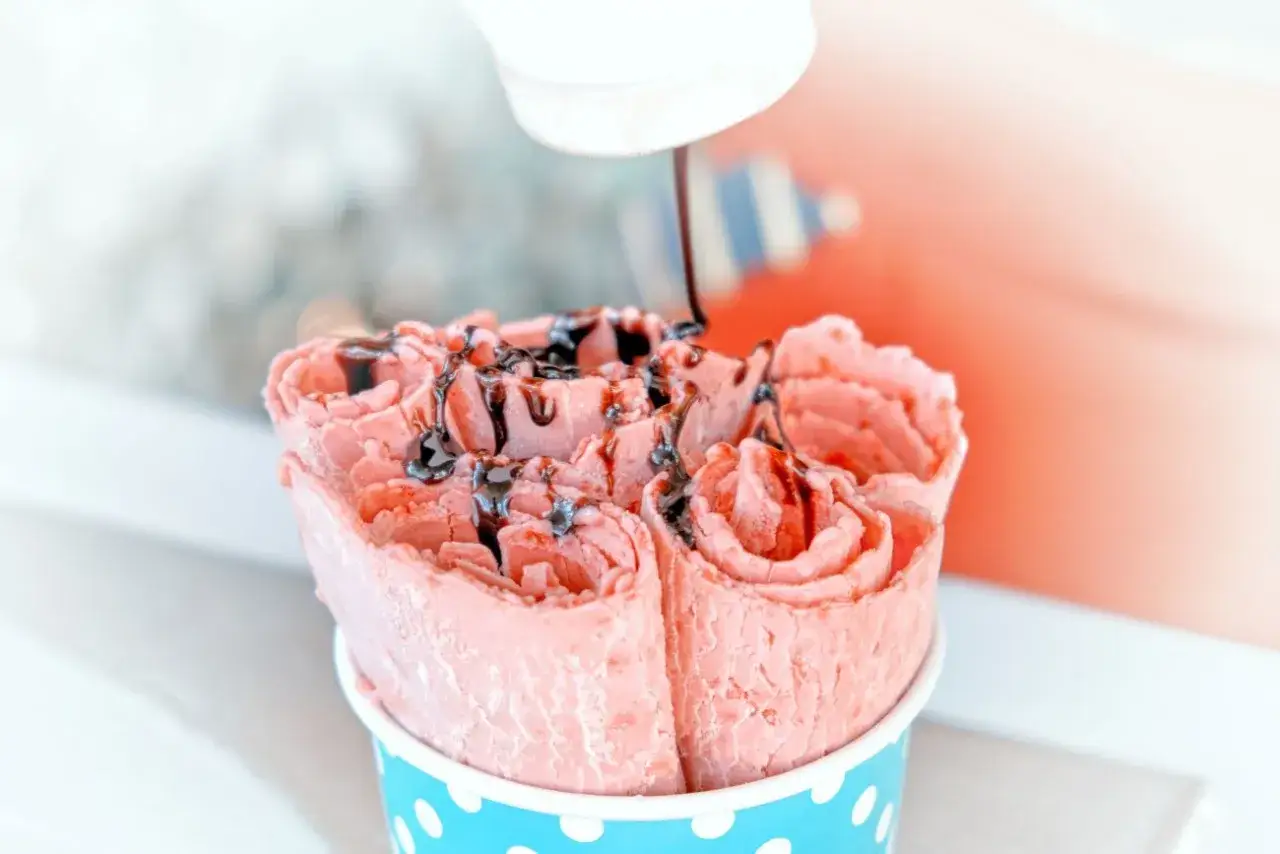 Różowe lody tajskie w kubeczku, polane czekoladą. Idealne, gdy chcesz wiedzieć, jak zrobić lody tajskie bez maszyny.